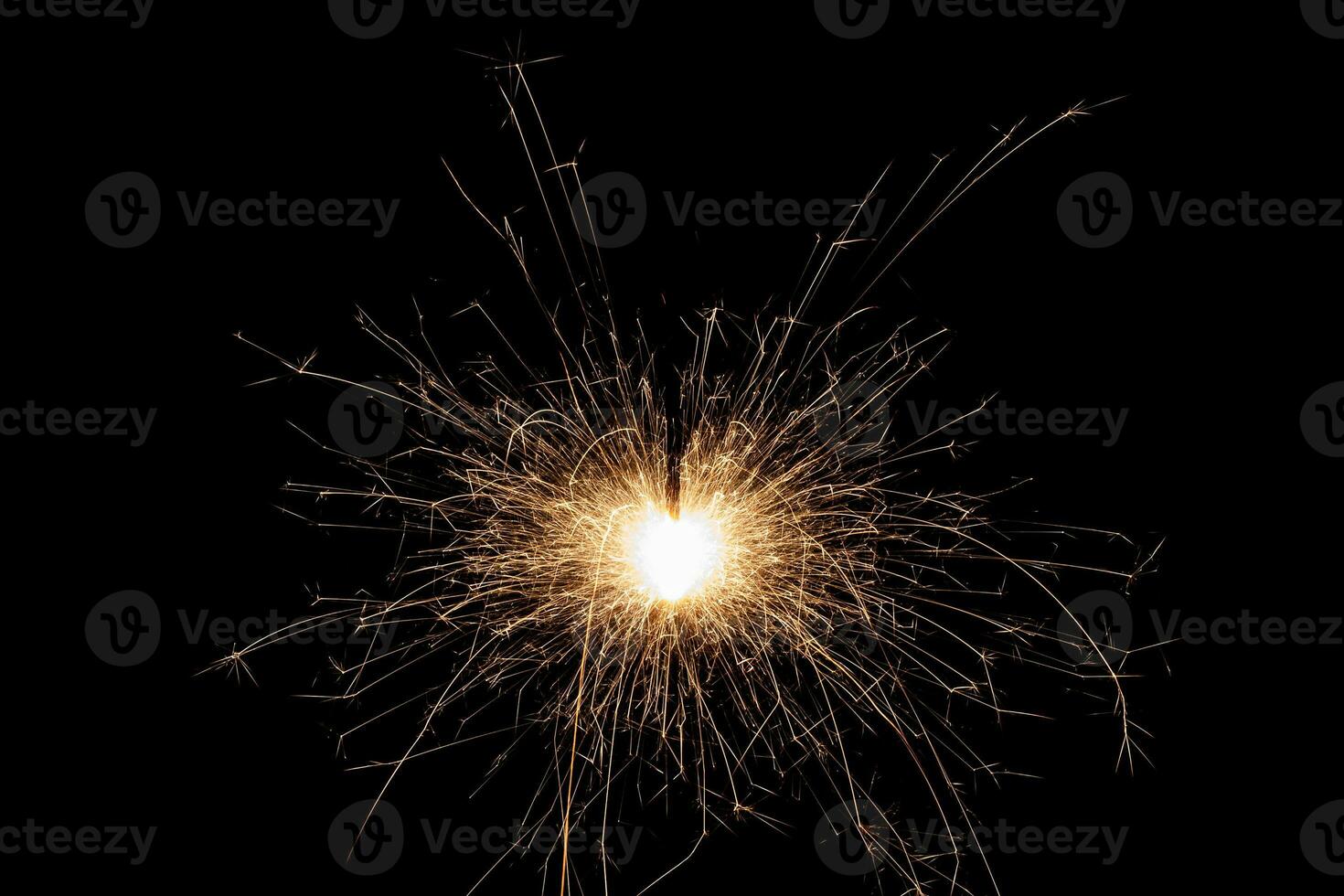 Burning sparkler isolated on black background. Fireworks theme. Light effect and texture. photo