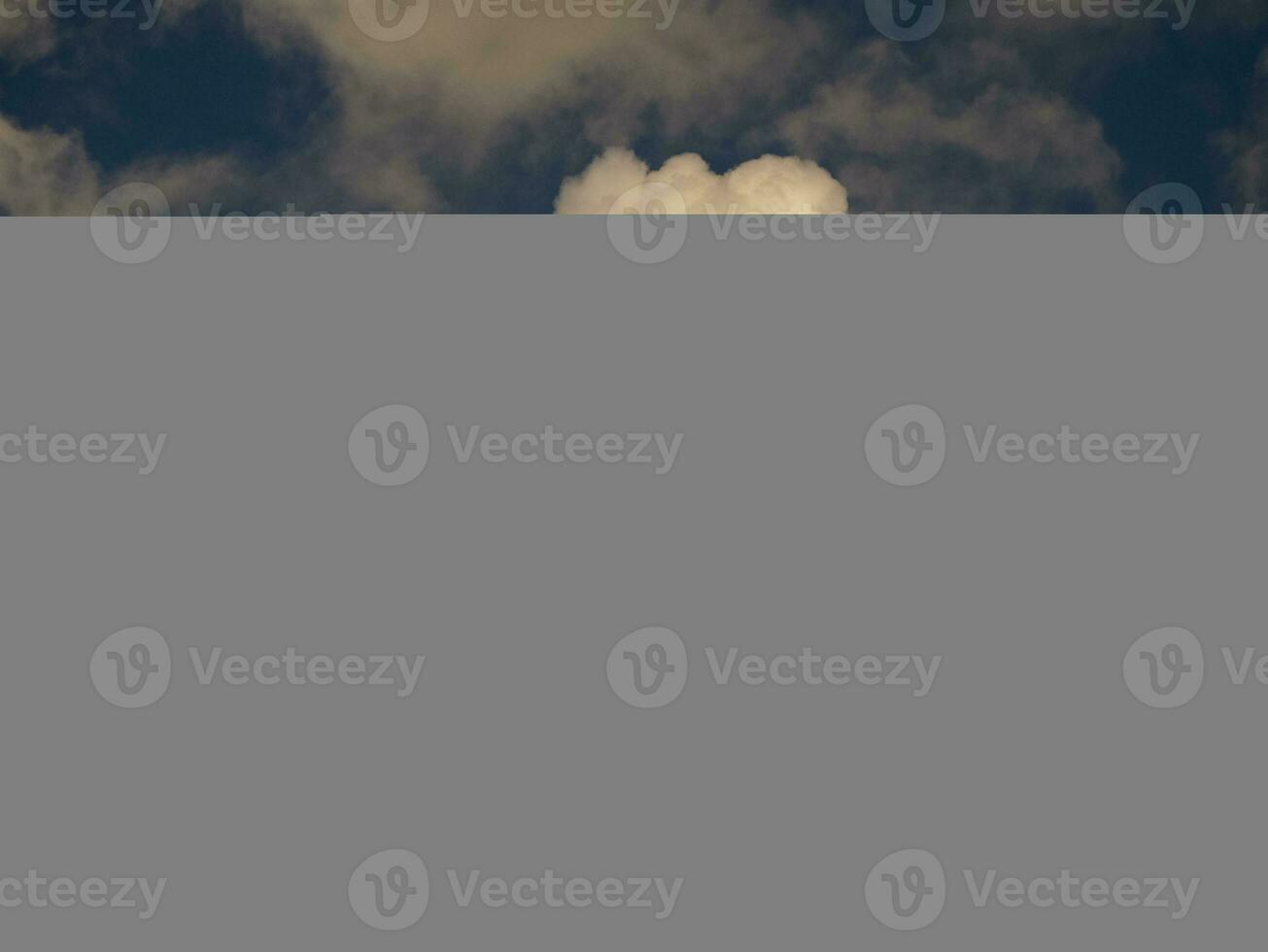 Fluffy clouds over sunset sky. Fluffy cumulus cloud shape photo, gloomy cloudscape background, smoke in the sky photo