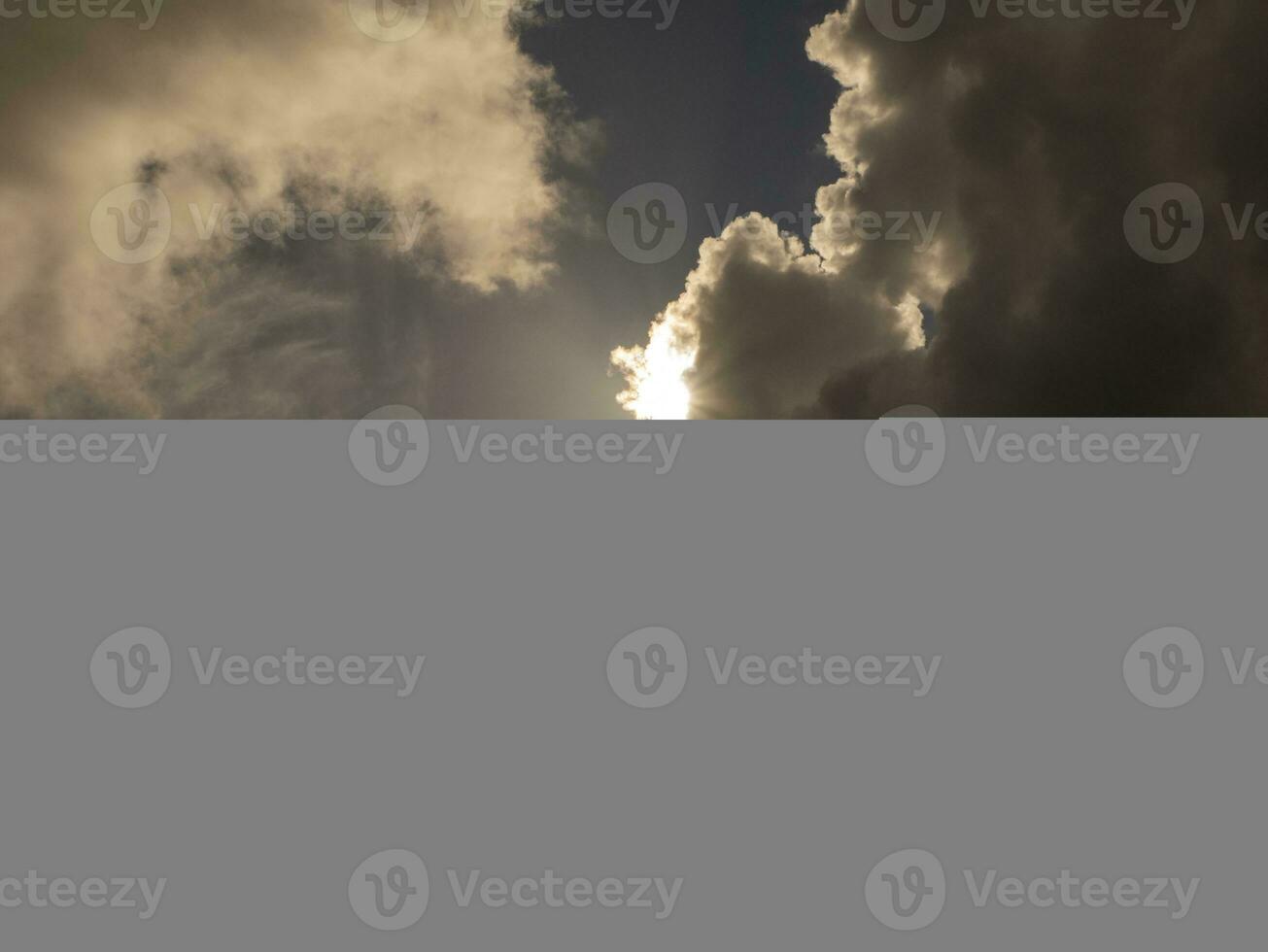 Fluffy clouds over sunset sky. Fluffy cumulus cloud shape photo, gloomy cloudscape background, smoke in the sky photo