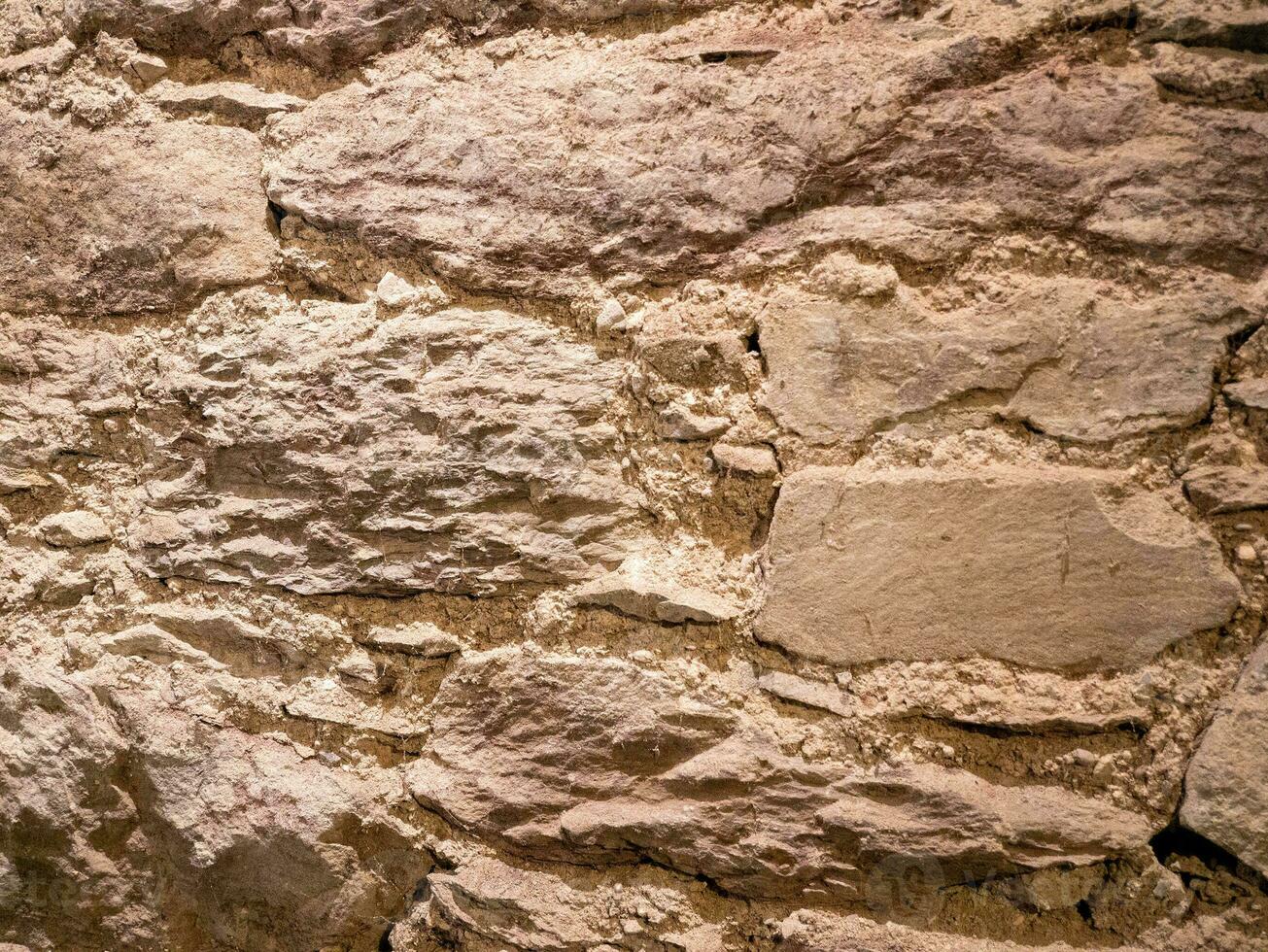 Old stone wall pattern close view background, ancient bricks surface. Natural rock wall photo