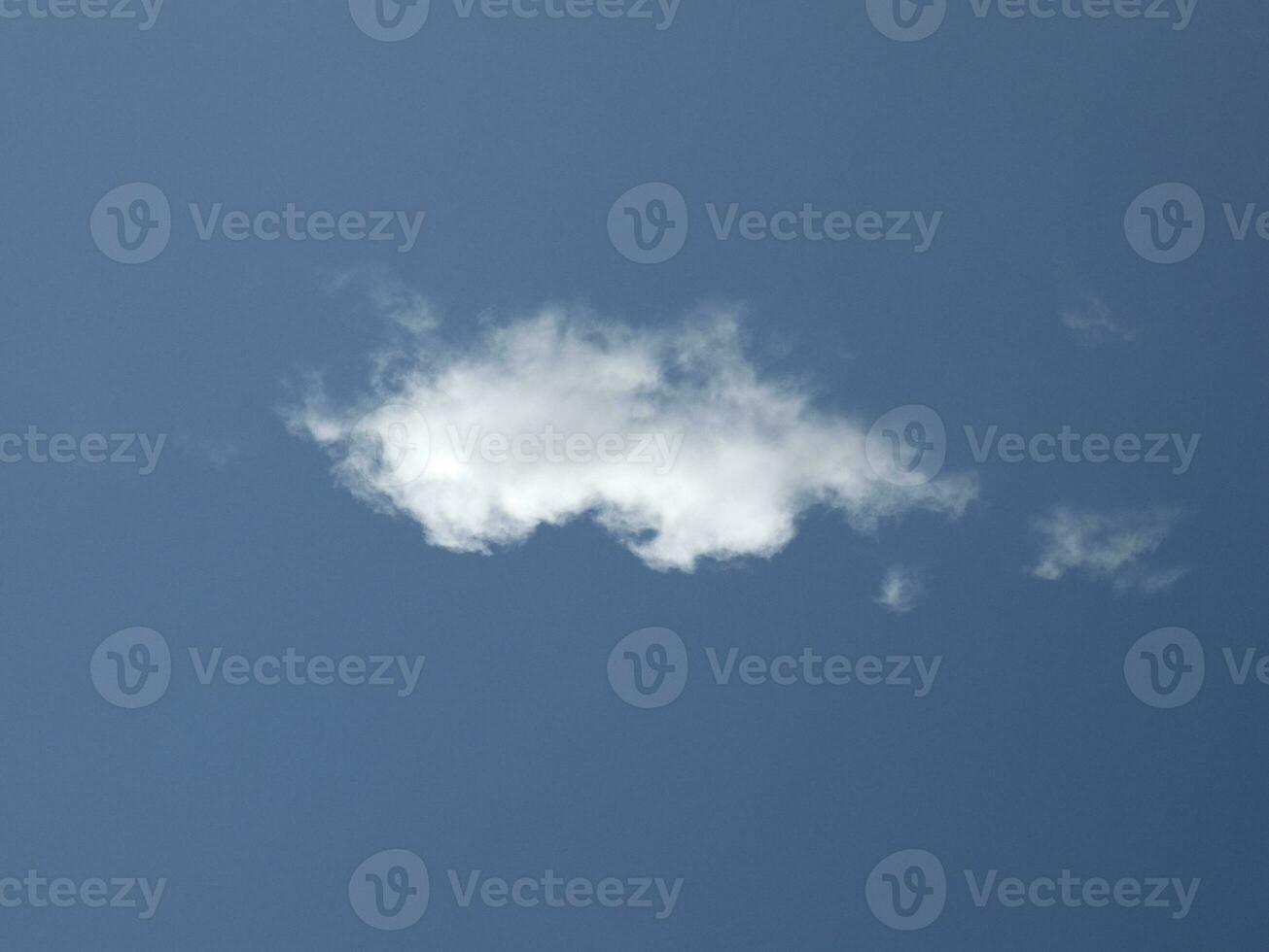 Single white cloud over blue sky background. Fluffy cumulus cloud shape photo