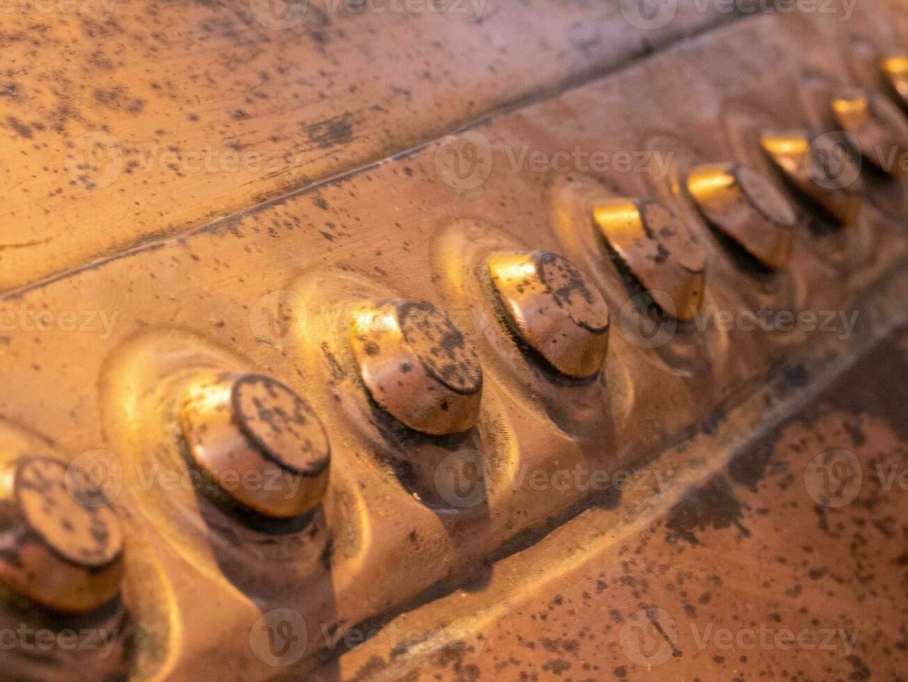 Metal background, old copper wall with rivets photo