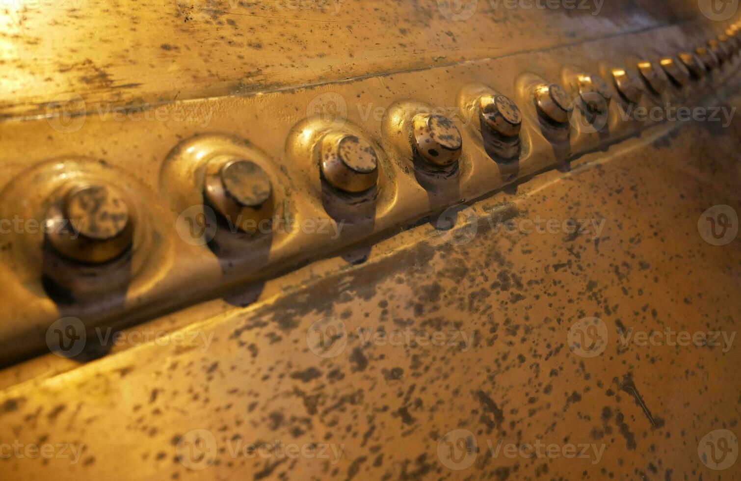 Metal background, old copper wall with rivets photo