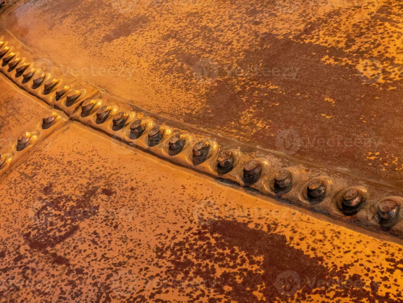 Metal background, old copper wall with rivets photo