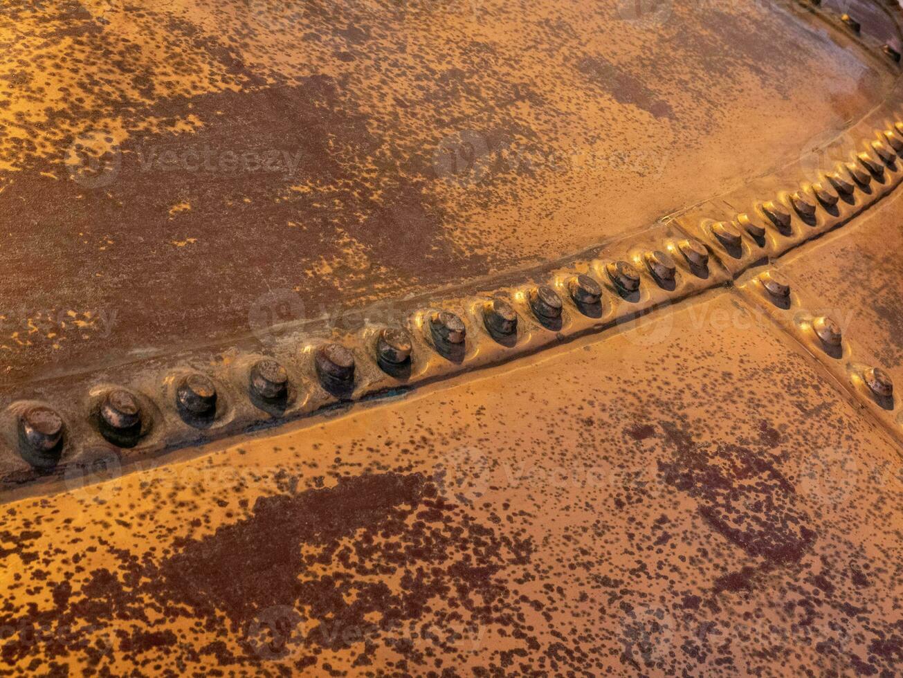 Metal background, old copper wall with rivets photo