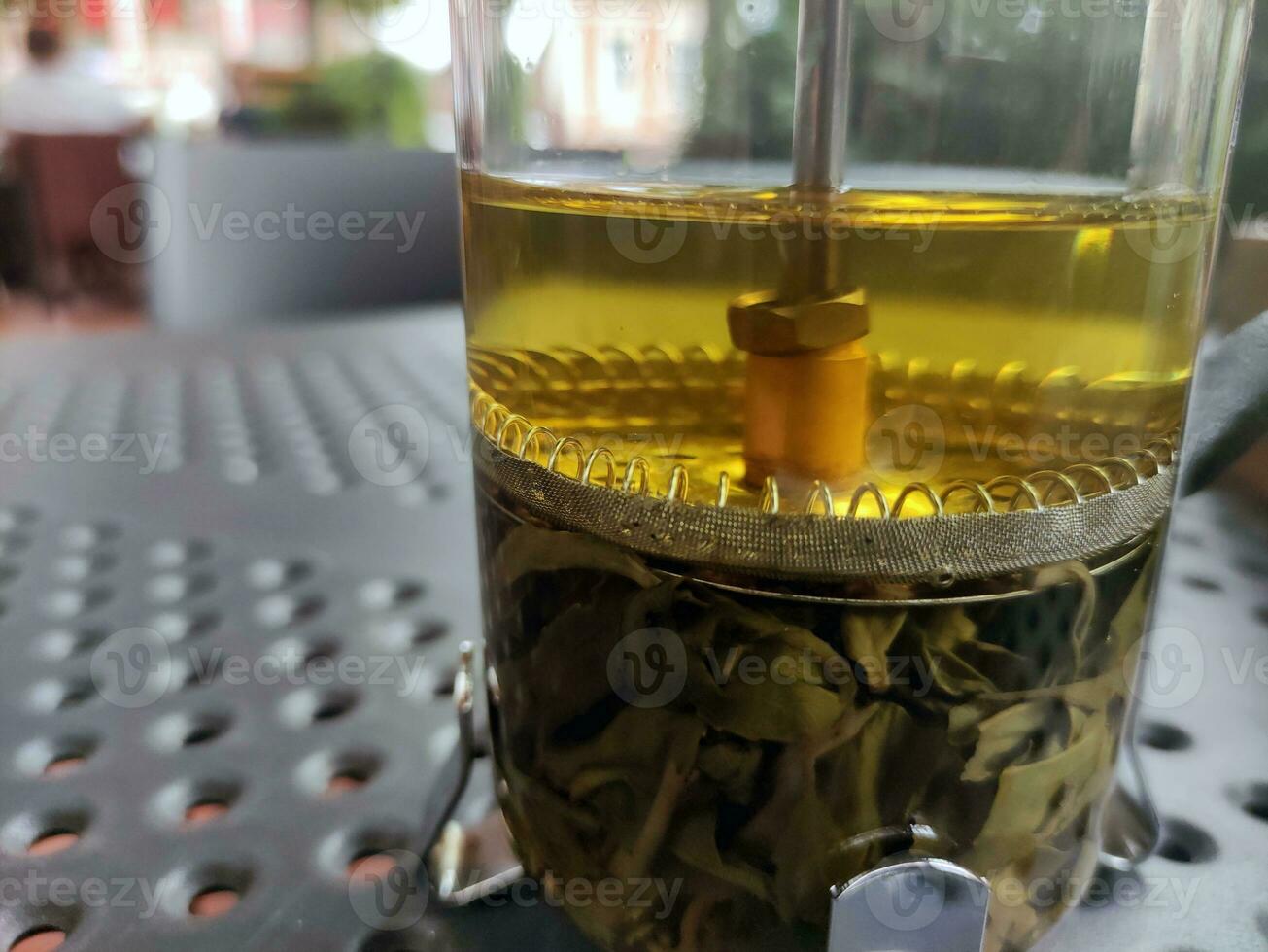 Green tea in a transparent glass kettle photo