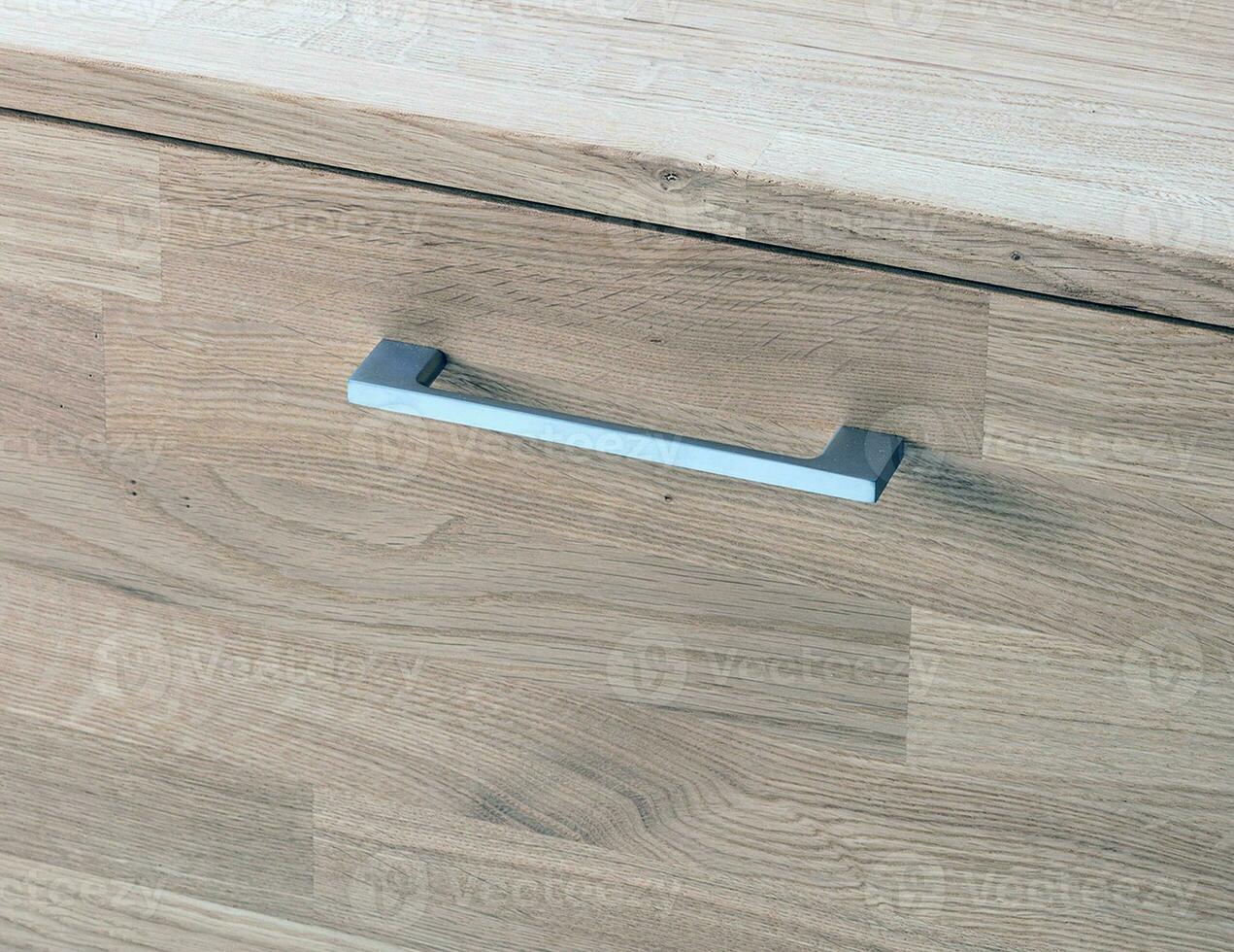 Wooden drawer with a handle close view photo, wooden furniture elements background. Furniture details photo