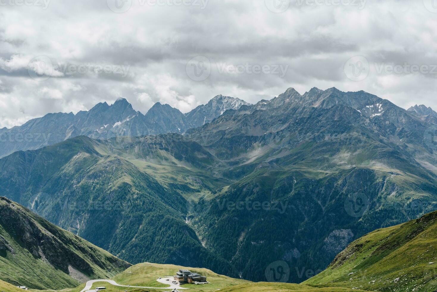 Dark mountains under rainy clouds and a small house on the edge photo