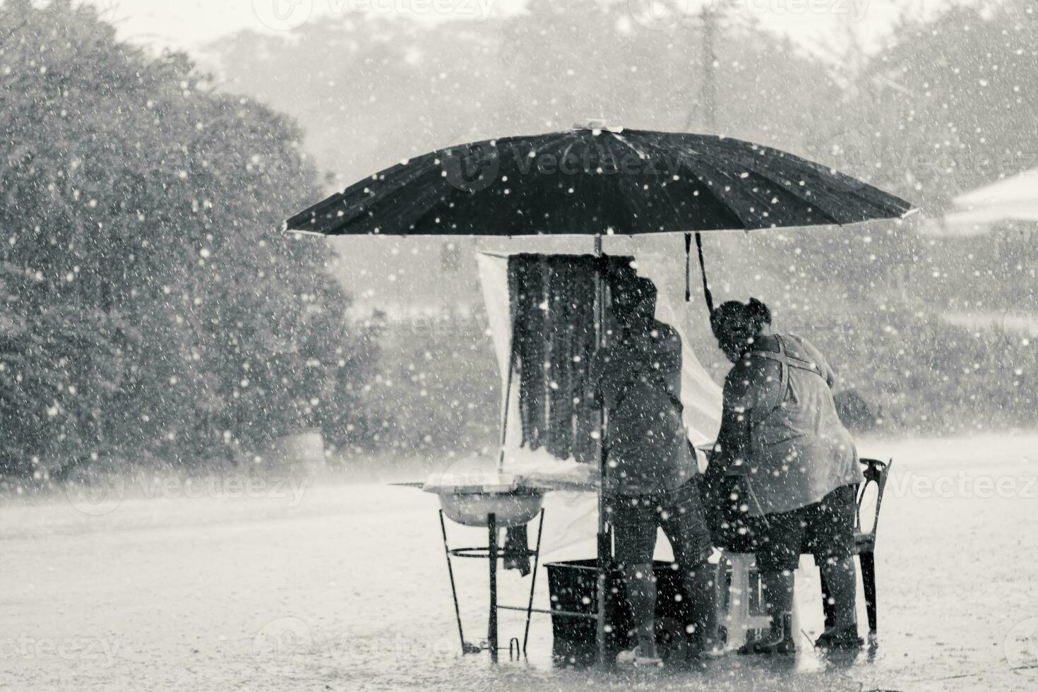 Two persons endure struggle on obstacles rainstorm photo