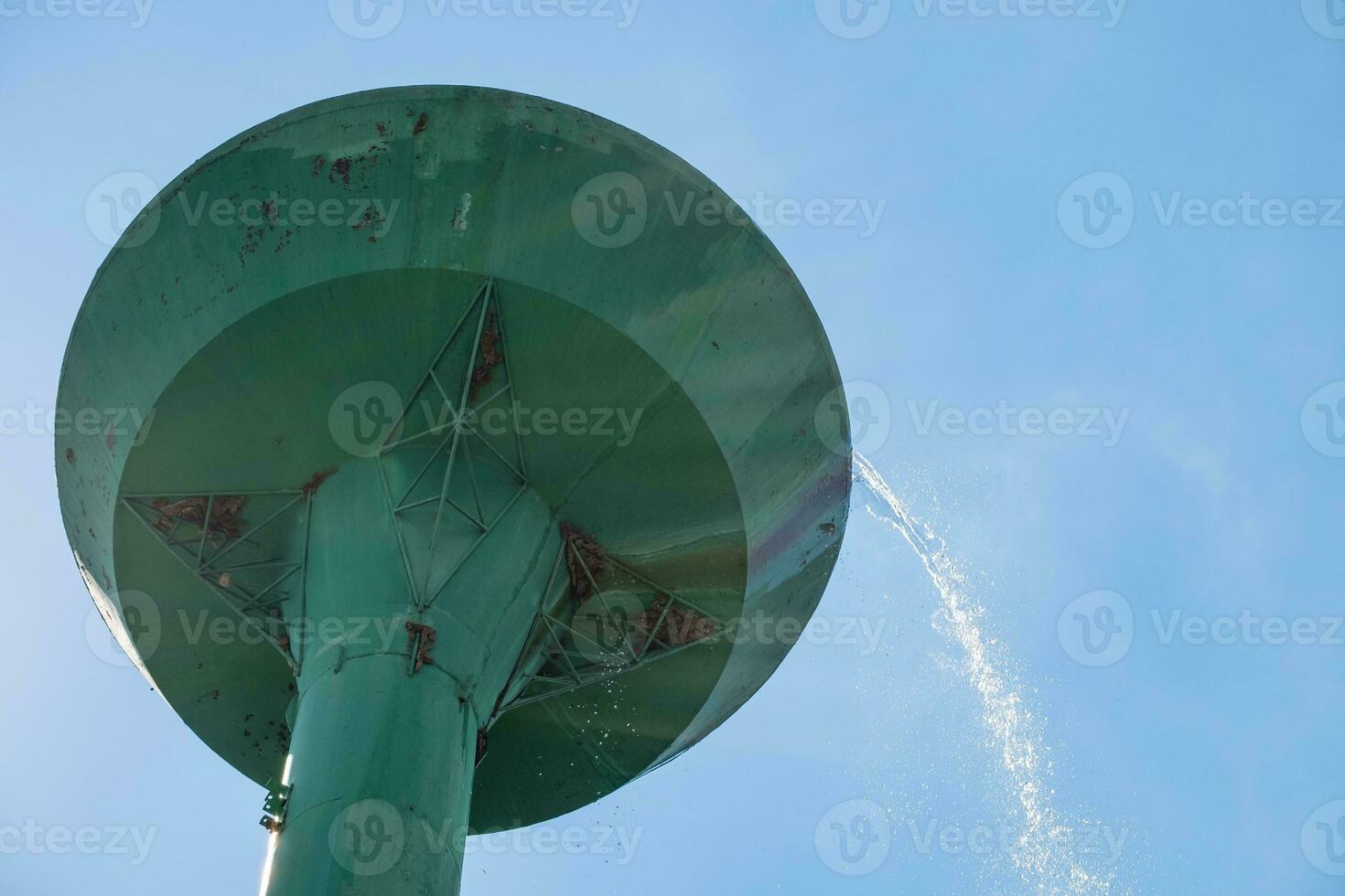 Water storage tank over flowing in green large photo