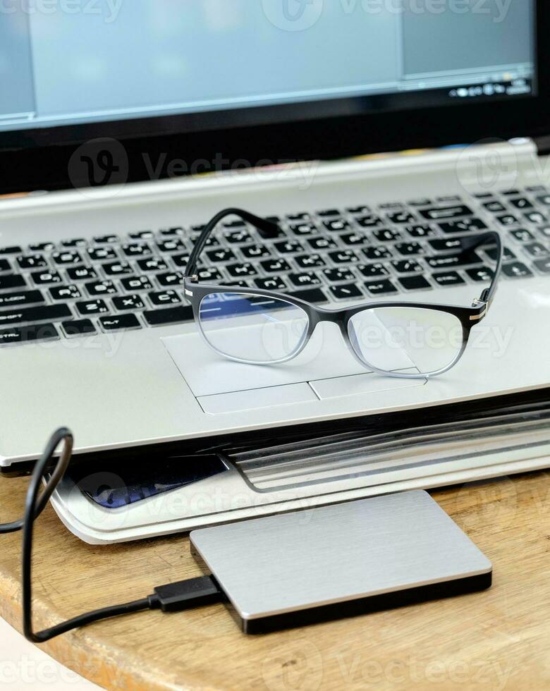 Notebook grey modern black keyboard with hdd grey and spectacles photo
