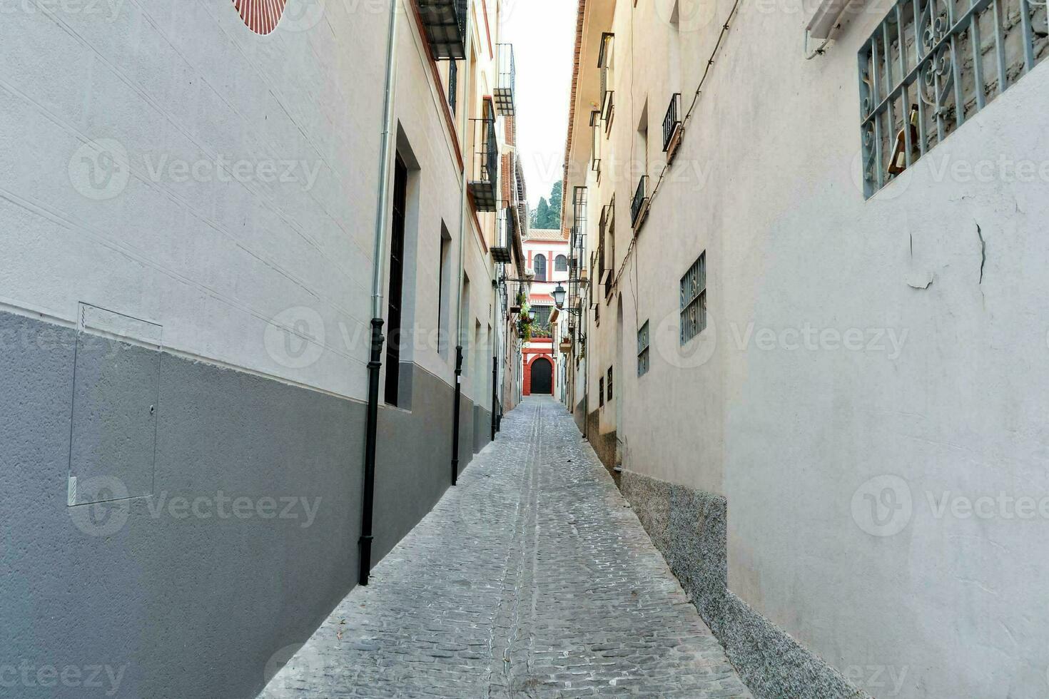 a narrow street with white buildings photo