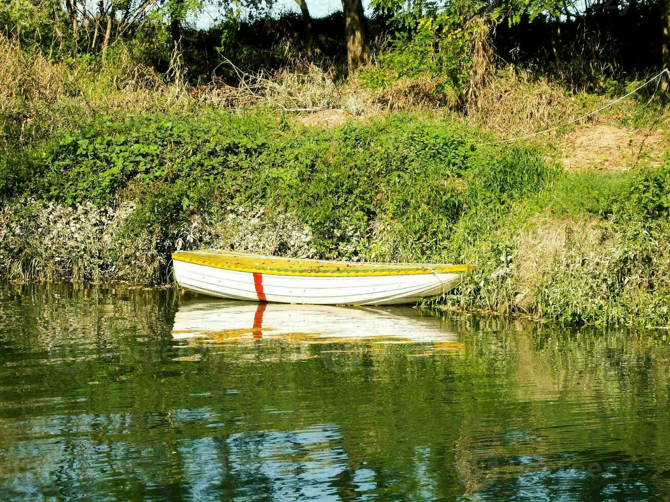 a small boat is sitting on the shore of a river photo