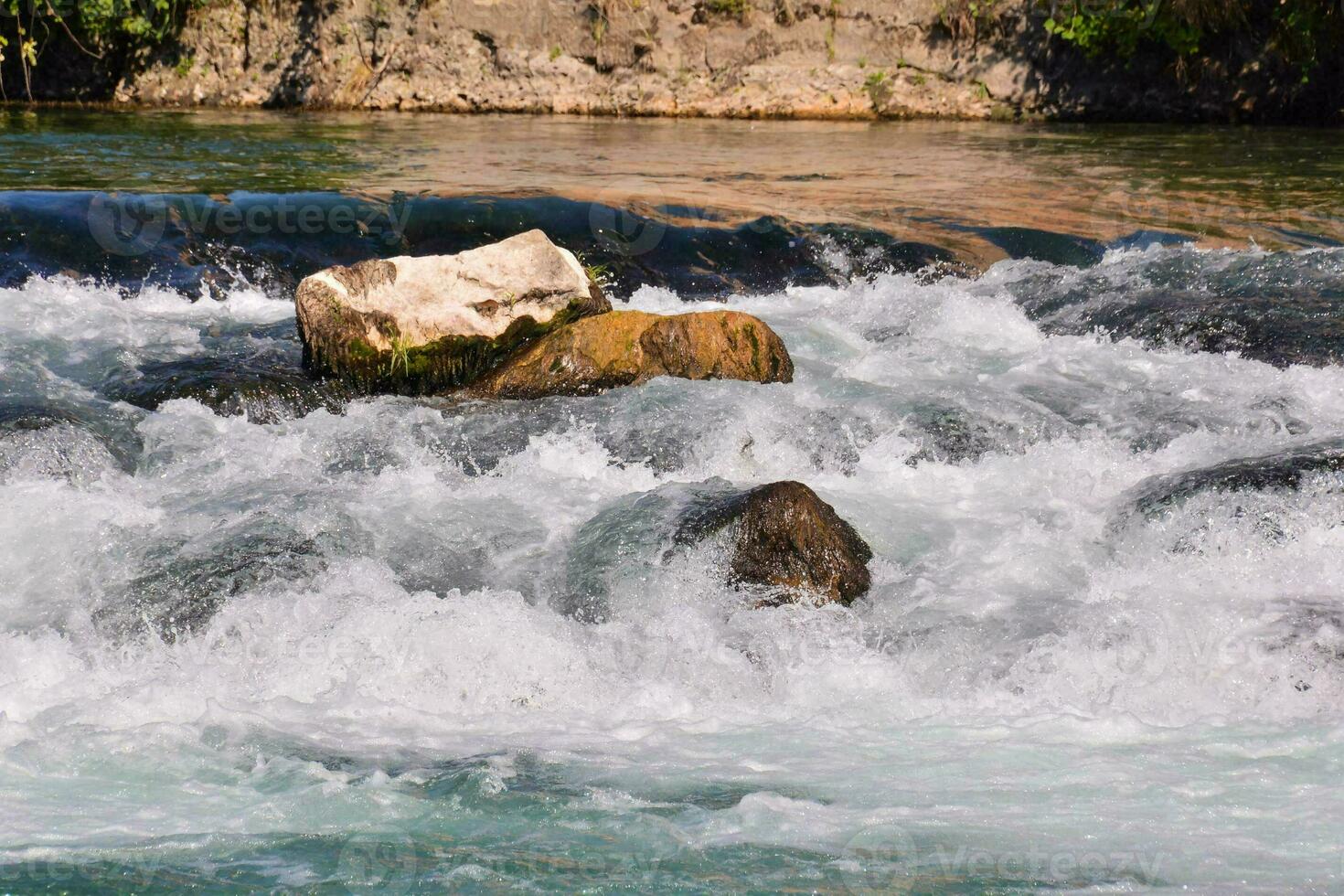 a river with rapids and rocks in the water photo