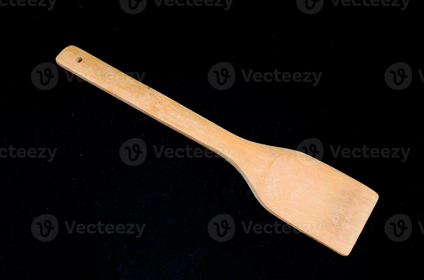 a wooden spatula on a black background photo