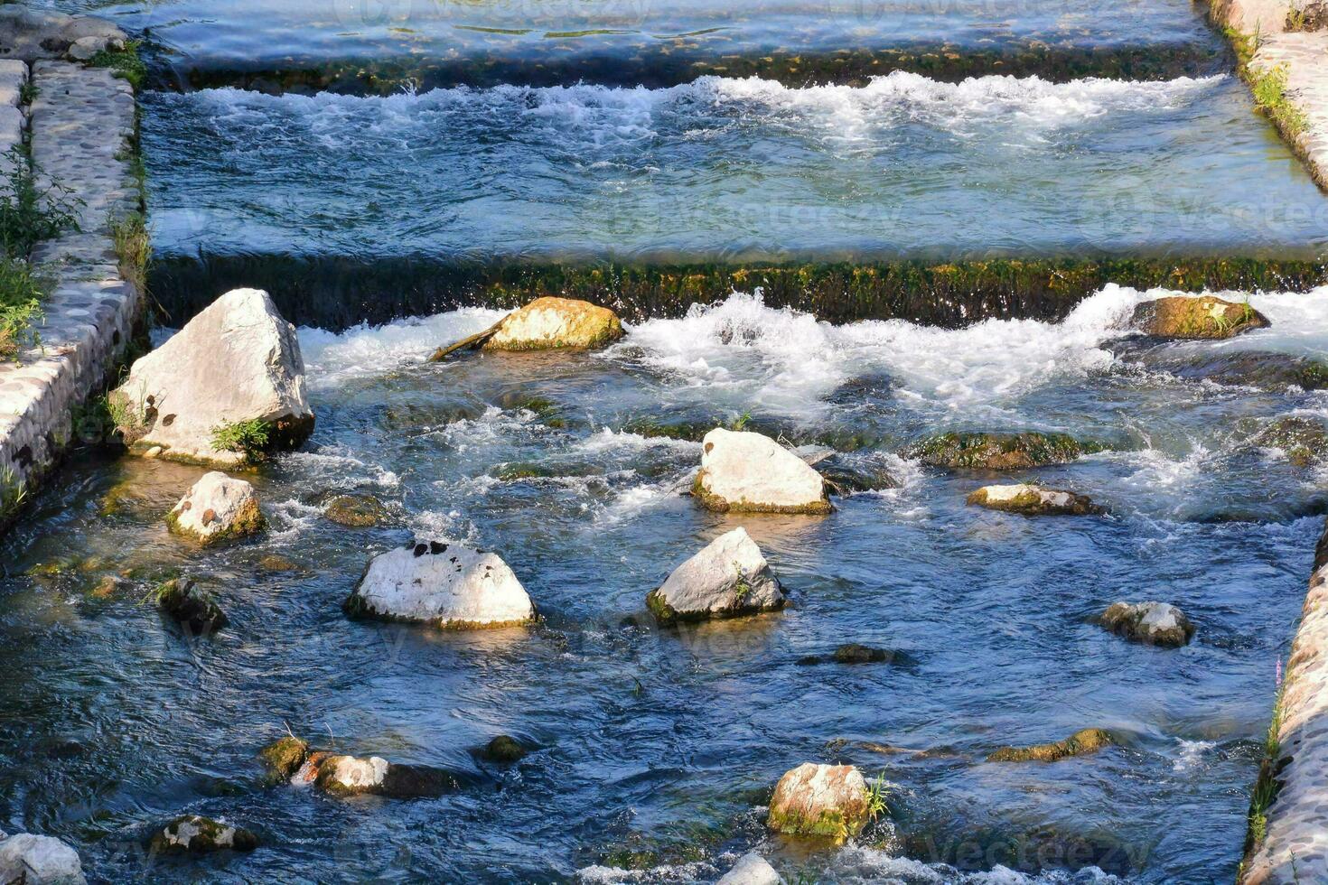 un río con rocas y agua fluido mediante eso foto