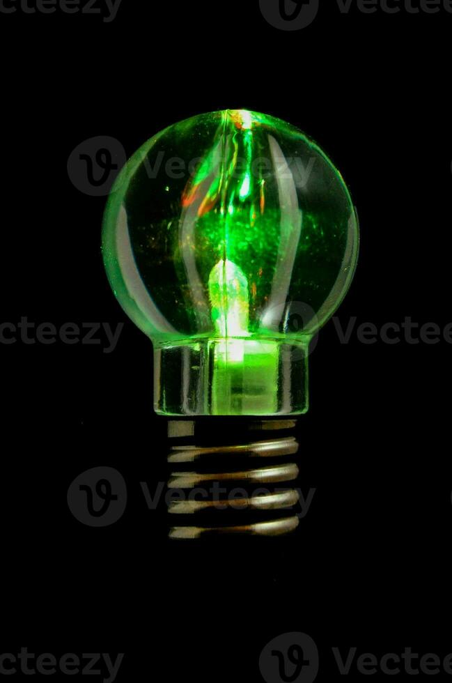 a green light bulb with a black background photo