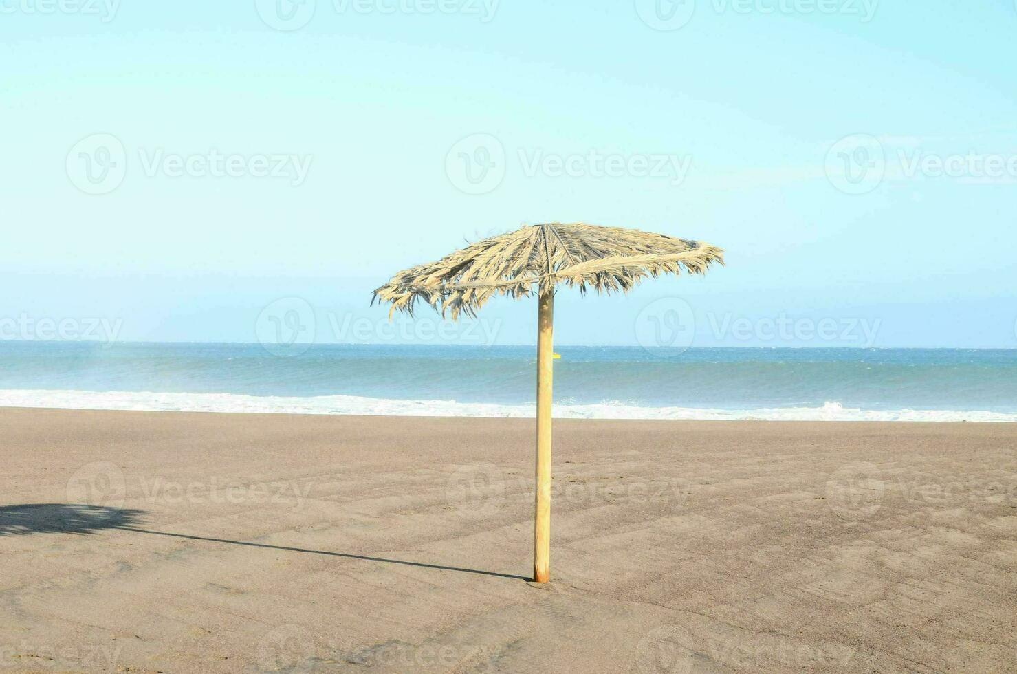 a straw umbrella on the beach photo