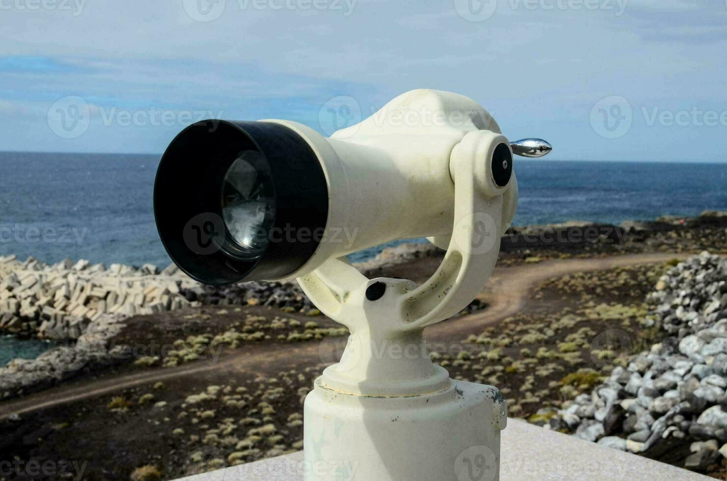 a white light on top of a pole near the ocean photo