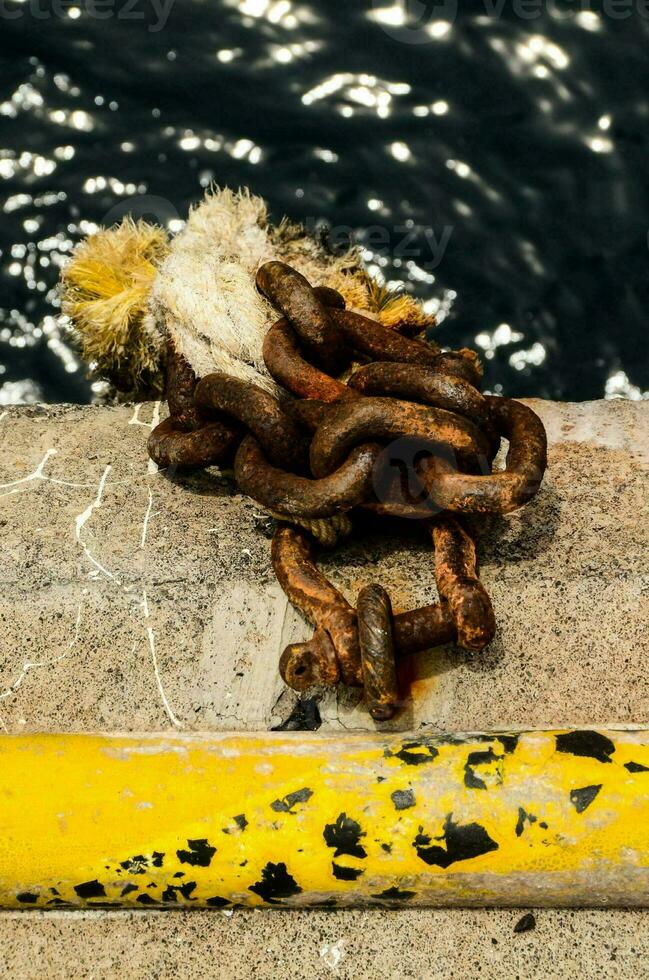 a chain and a yellow rope on the side of a dock photo