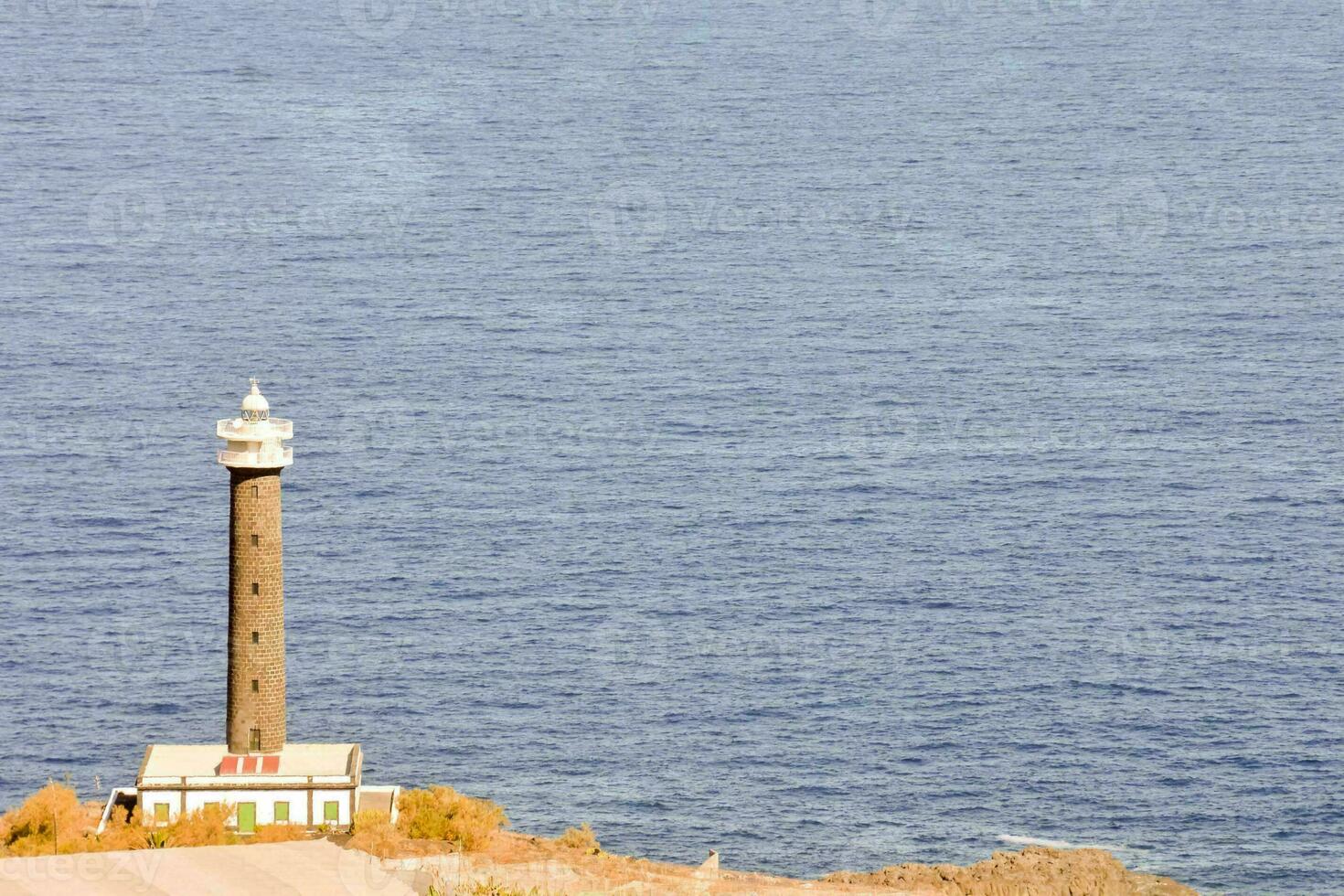 a lighthouse on a cliff overlooking the ocean photo