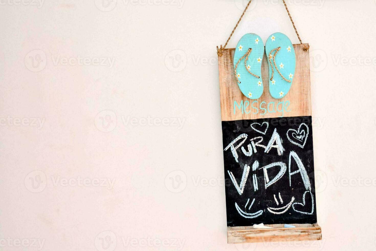 a sign with the words pura vida hanging on a wall photo