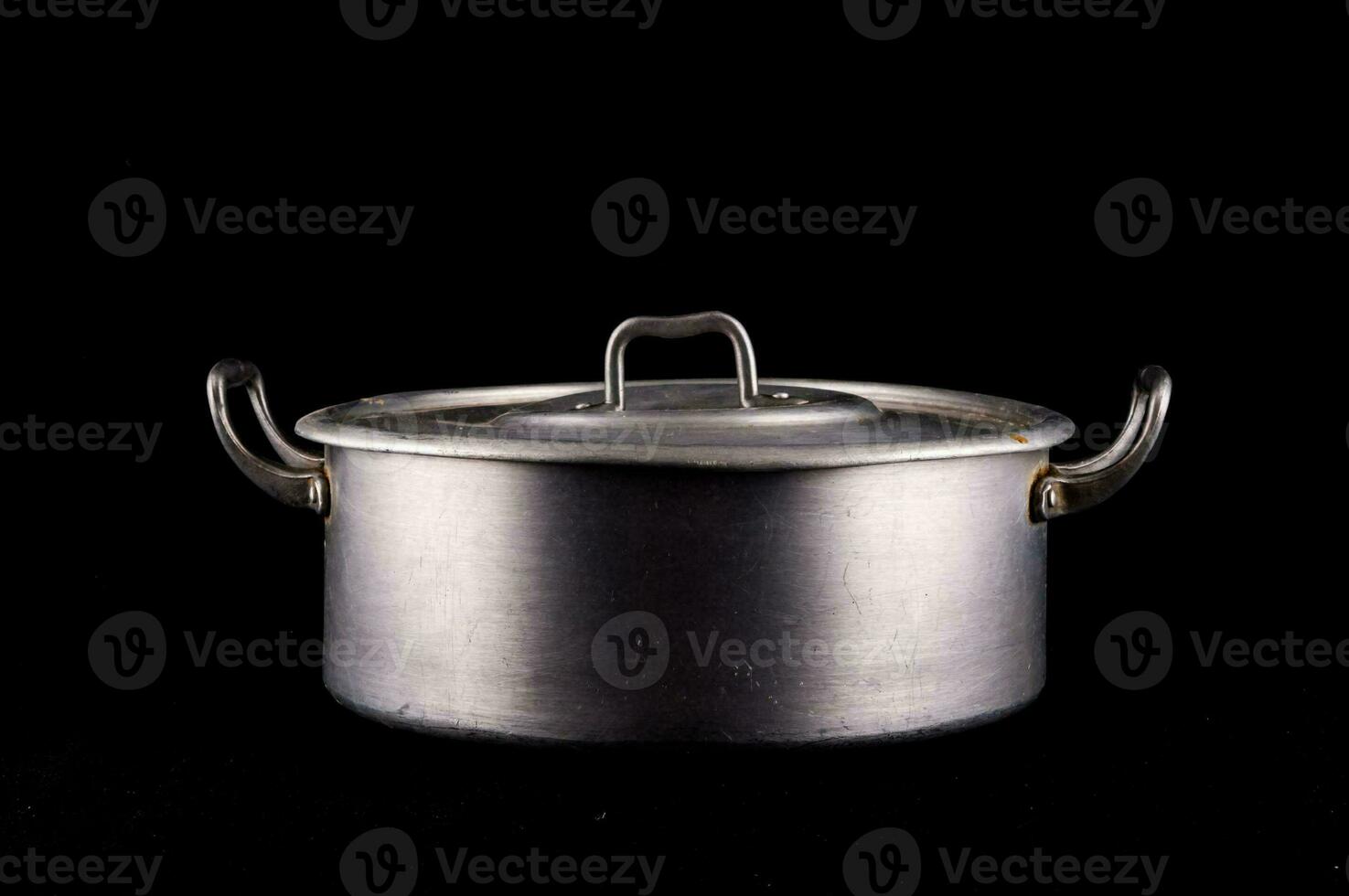 a metal pot with a lid on a black background photo