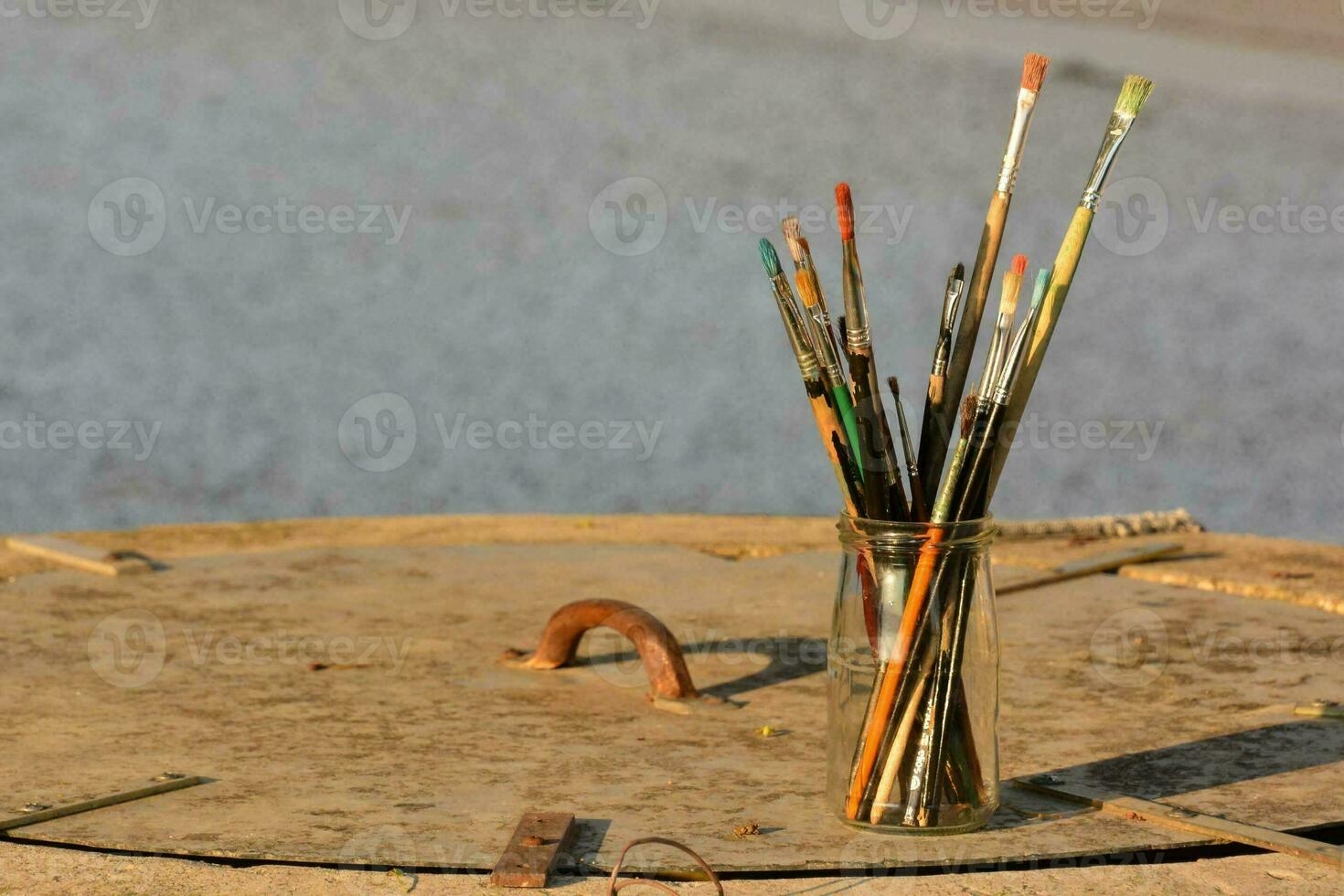 a vase with a bunch of paint brushes in it photo