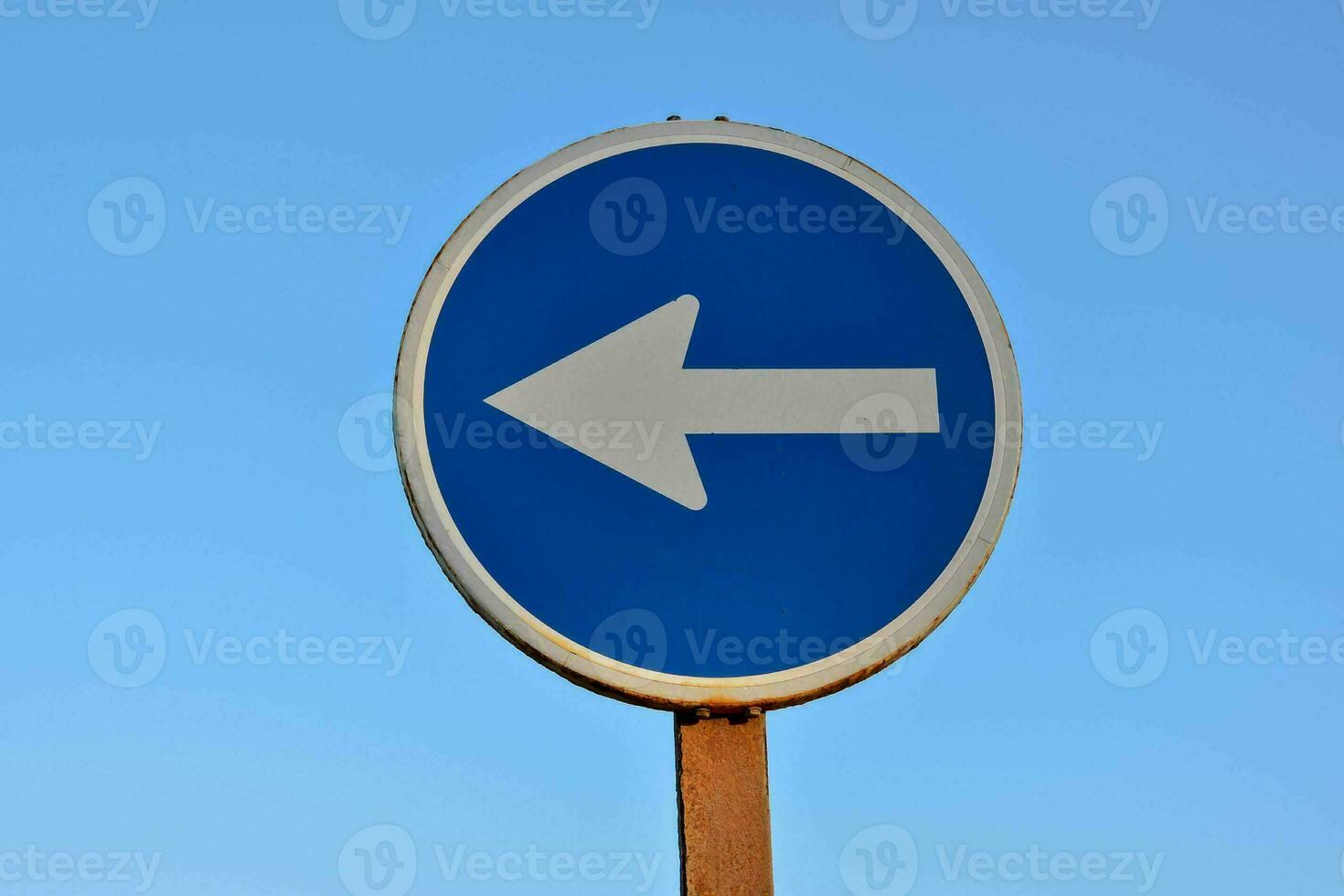 a blue and white sign with an arrow photo