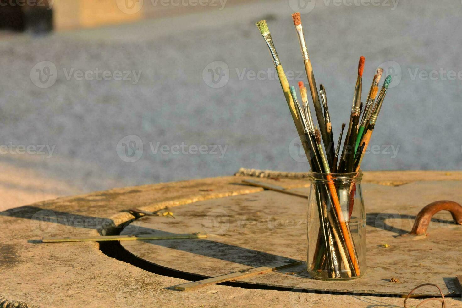 un florero lleno con pintar cepillos en un Roca mesa foto