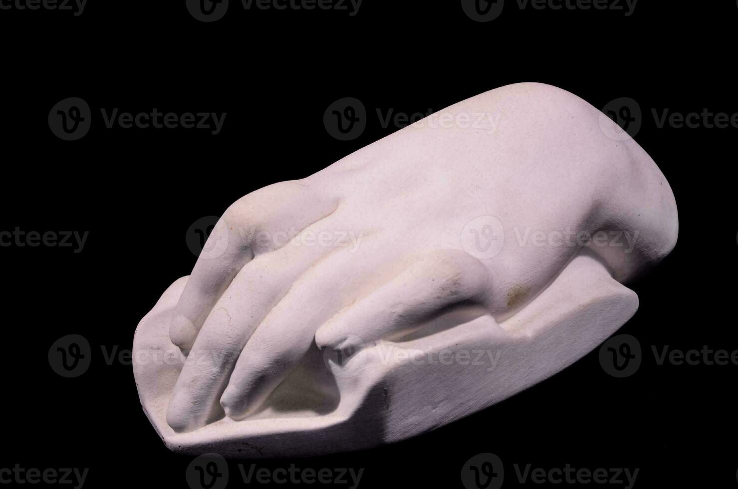 a white hand sculpture on a black background photo