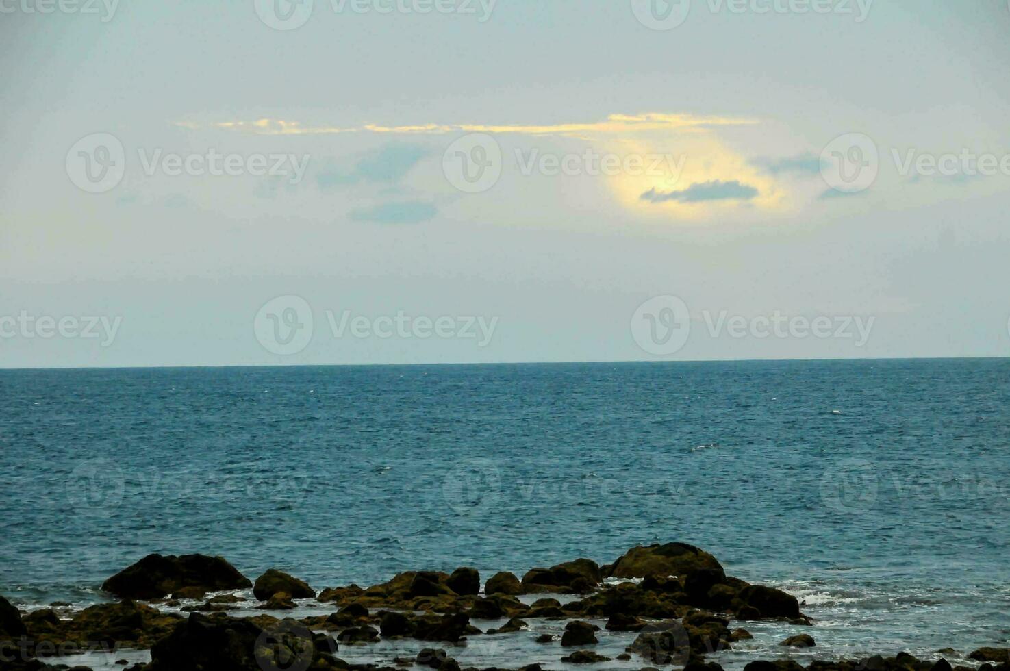 a view of the ocean from a rocky shore photo