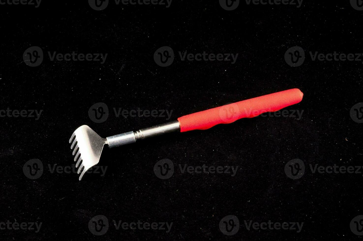 A tool resembling a fork isolated on black background photo