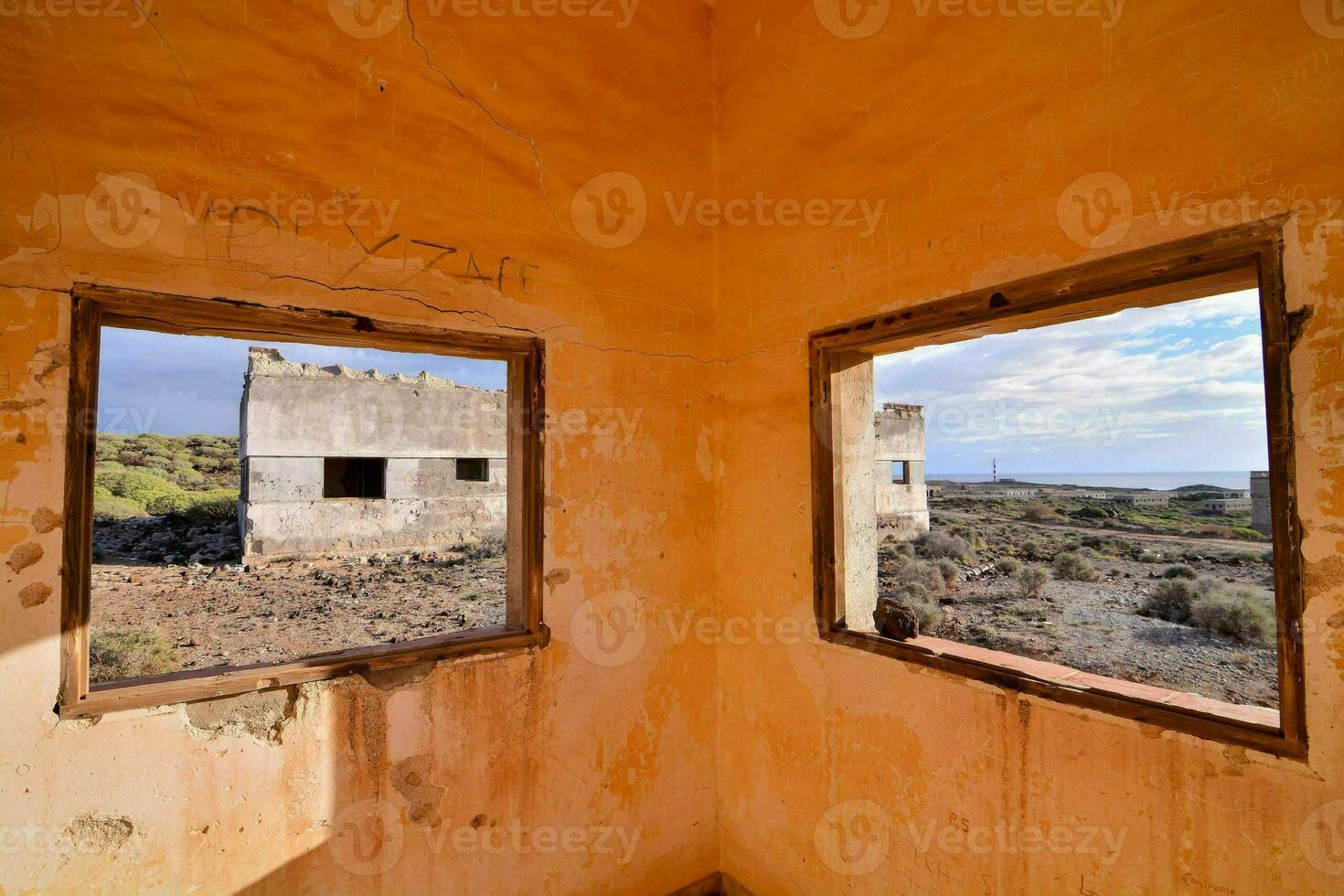 dos ventanas en un abandonado edificio con un ver de el Desierto foto