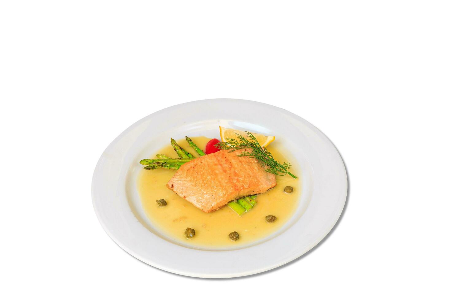 Salmon steak on the grill with asparagus  and herbs on white plate photo