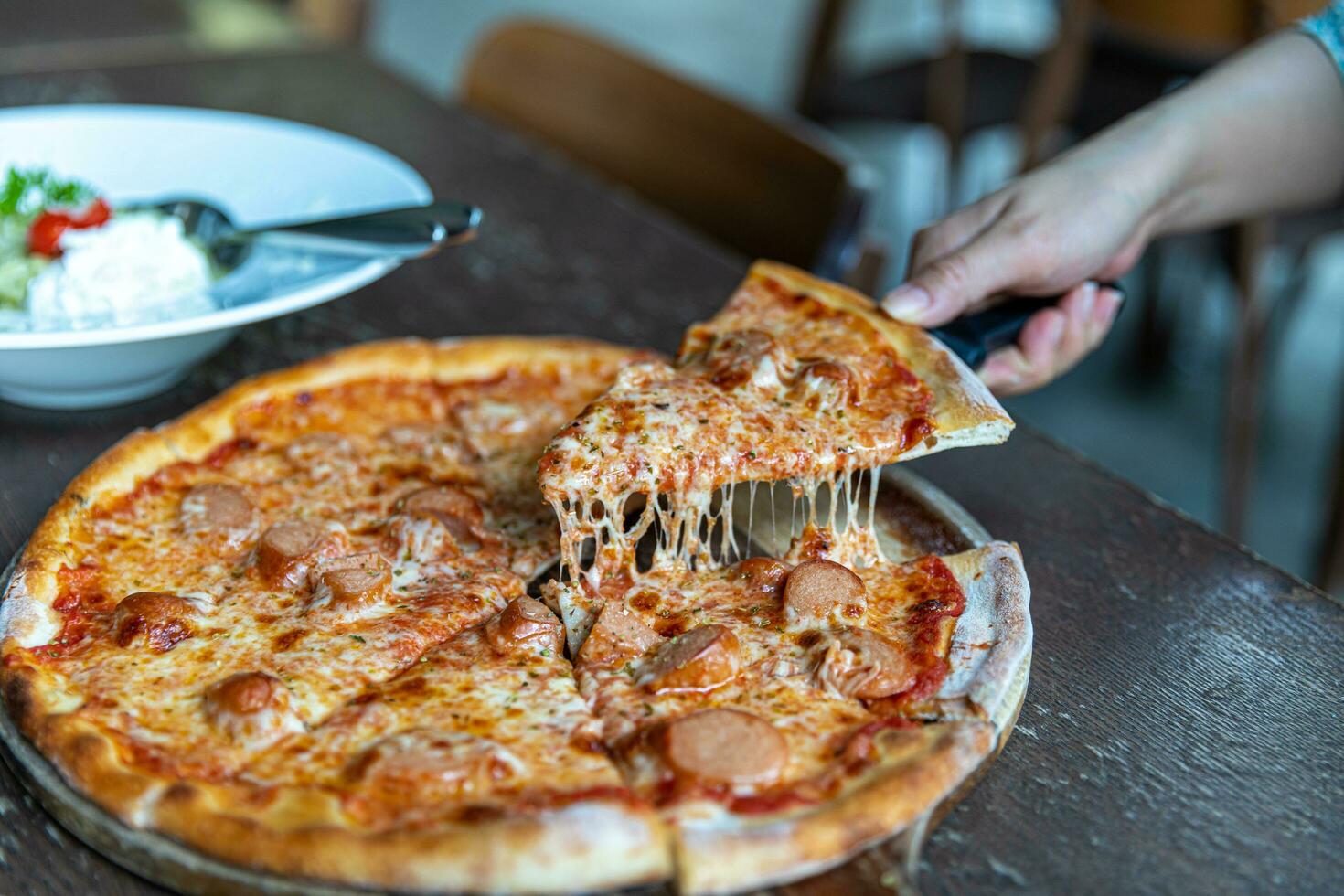 Pepperoni Pizza with Mozzarella cheese, salami, Tomatoes, pepper, Spices and Fresh Basil. Italian pizza. Pizza slice on wood dish photo