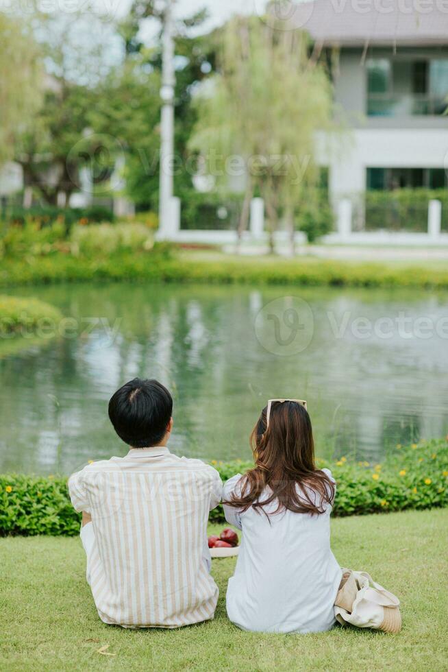 Asian couple sitting on garden . Man and woman tourist relax and enjoy outdoor lifestyle and holiday vacation. photo