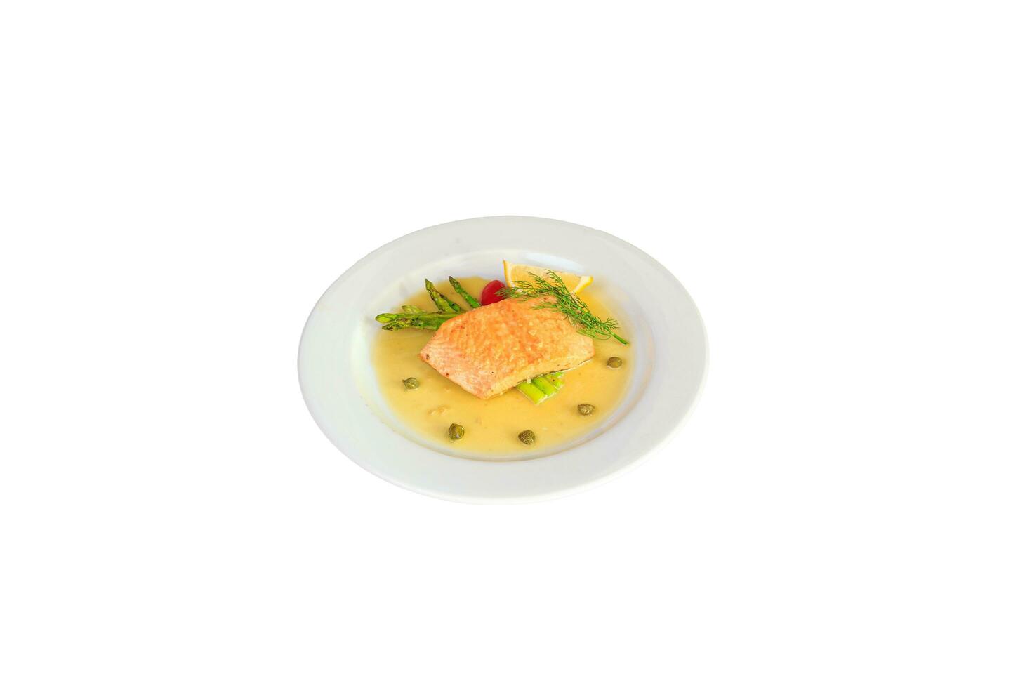 Salmon steak on the grill with asparagus  and herbs on white plate photo