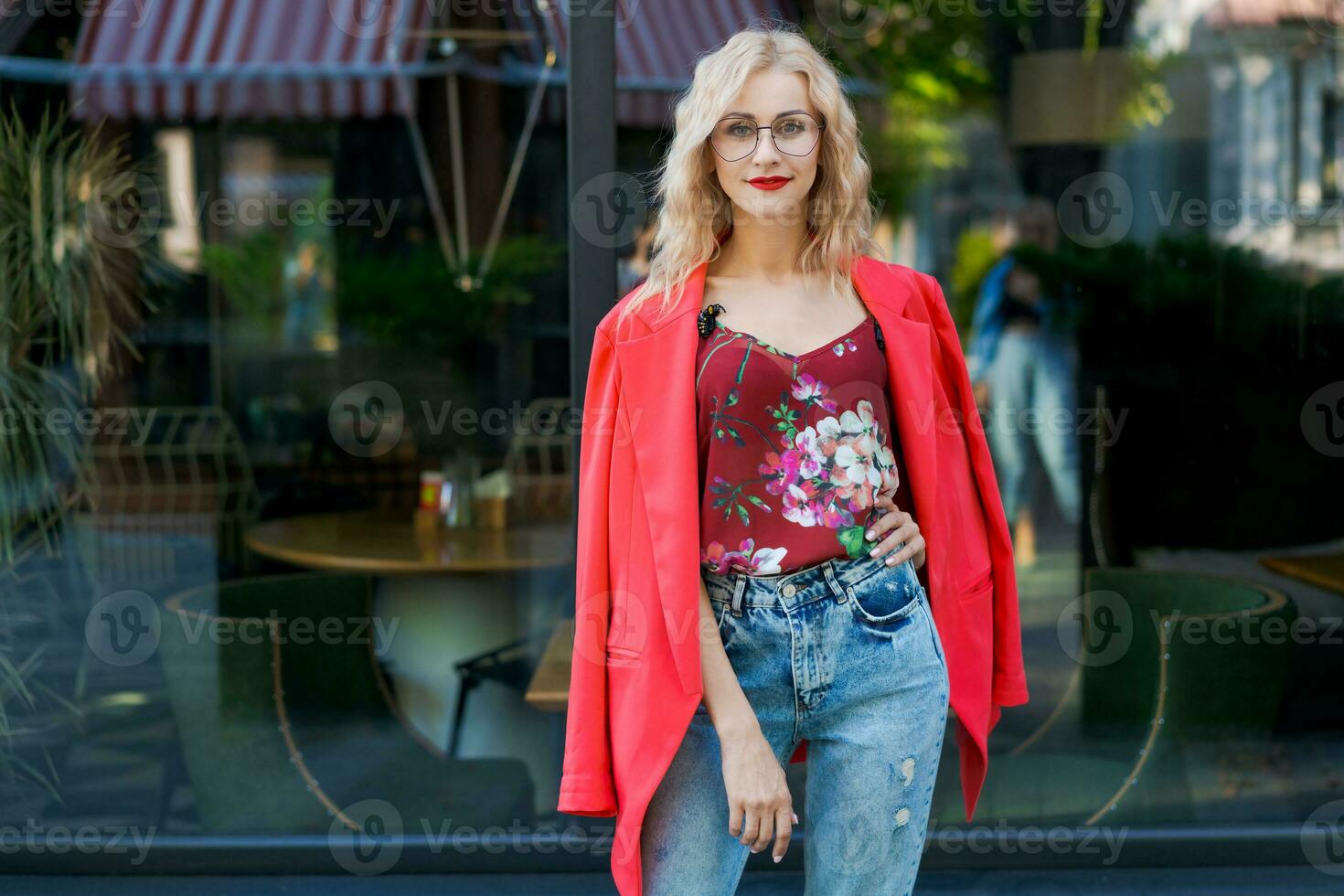 Redhead cute young hipster woman in stylish T-shirt in trendy sunglasses in  blue jeans poses