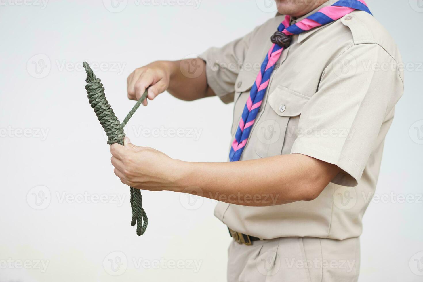 Keeping long rope to be shorter,  demonstrated by scout teacher trainer. Concept, useful tying knot for many purposes in daily life. Tying knot rope teaching aid. Life skills with rope. photo