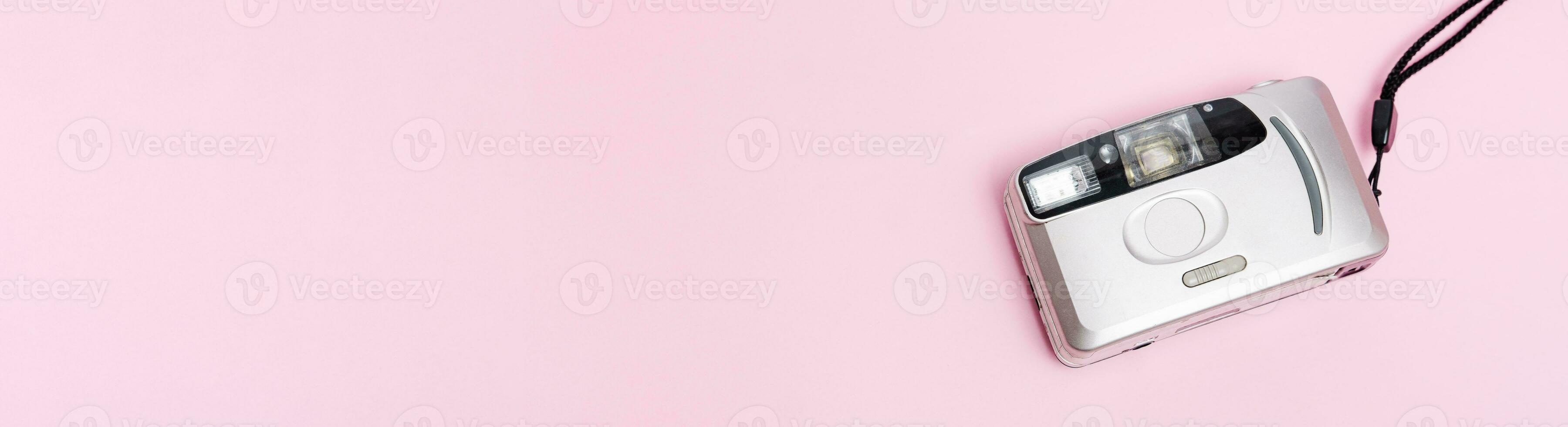 silver film camera banner on pink background top view photo