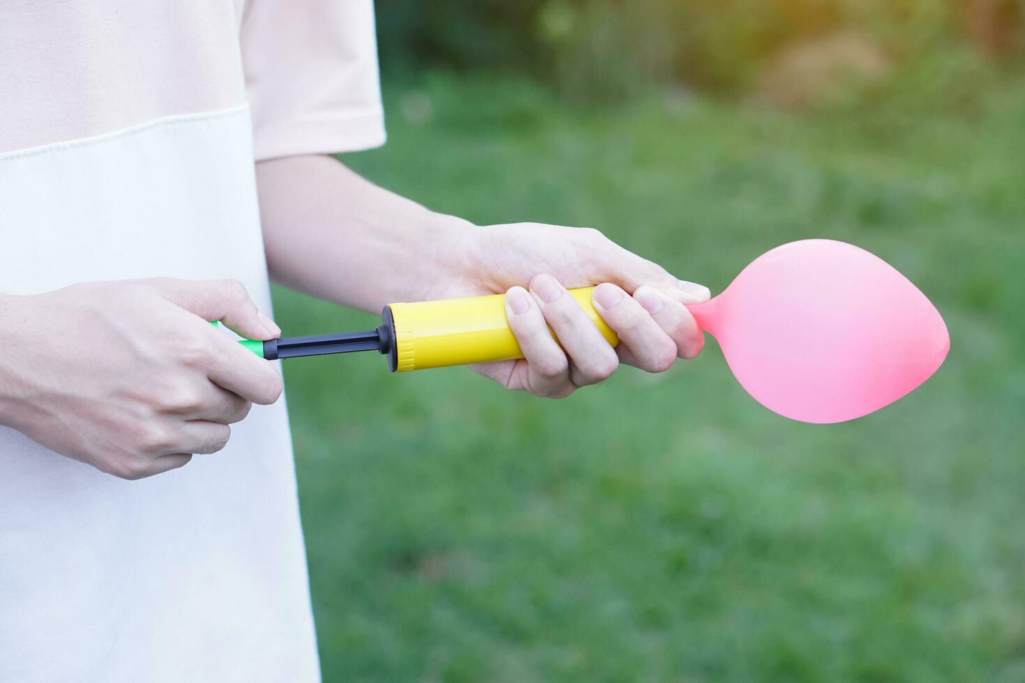 Blowing pink balloon by hand air pump, inflates  air to balloon Concept, children play, toy and equipment to play fun games or prepare party. photo