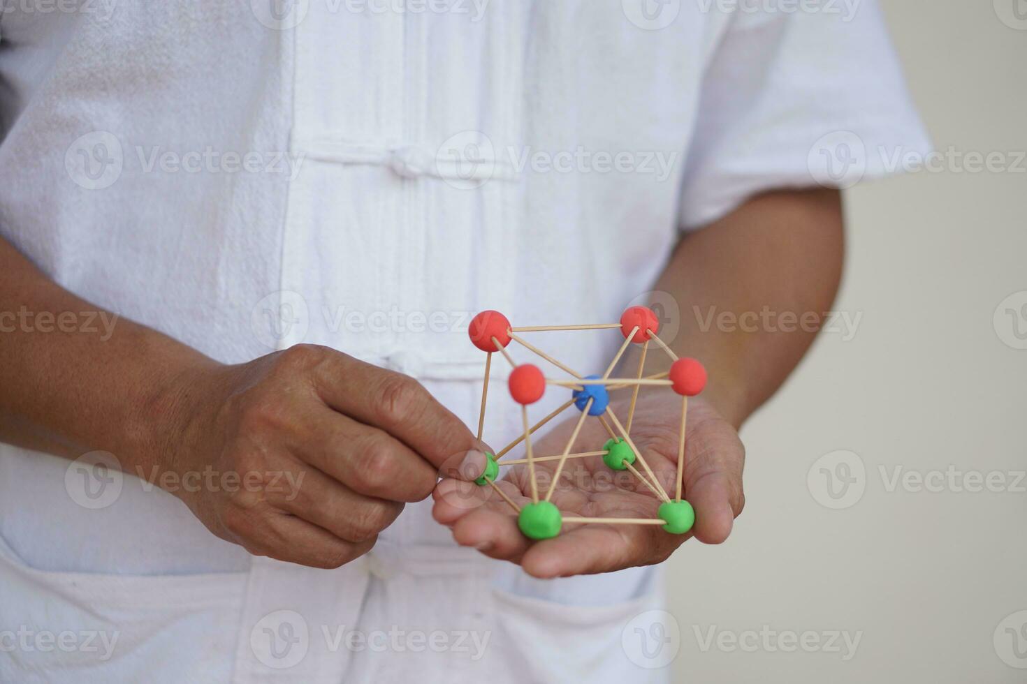 Closeup man hold DIY molecule structure made from toothpicks and plasticine for teaching. Concept, teaching aid, educational materials. science education activity, creative DIY craft that kids can do photo