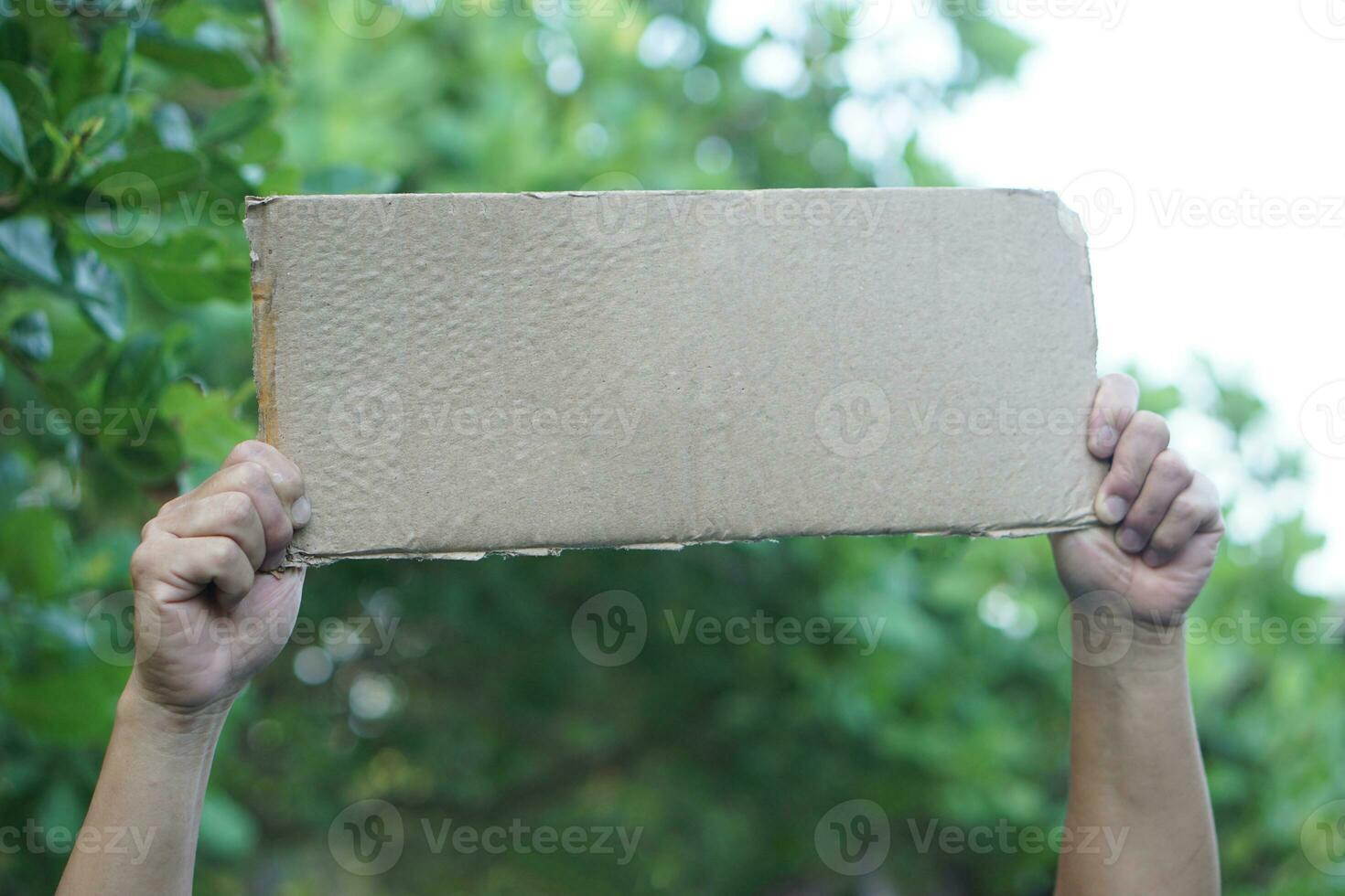 Close up hands hold blank paper cardboard for adding text or words. Concept, protest, campaign to do something. Sign, tag and notice. photo