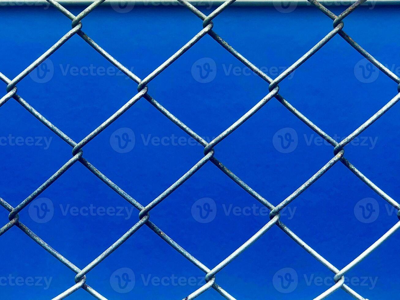 a blue background with a chain link fence photo