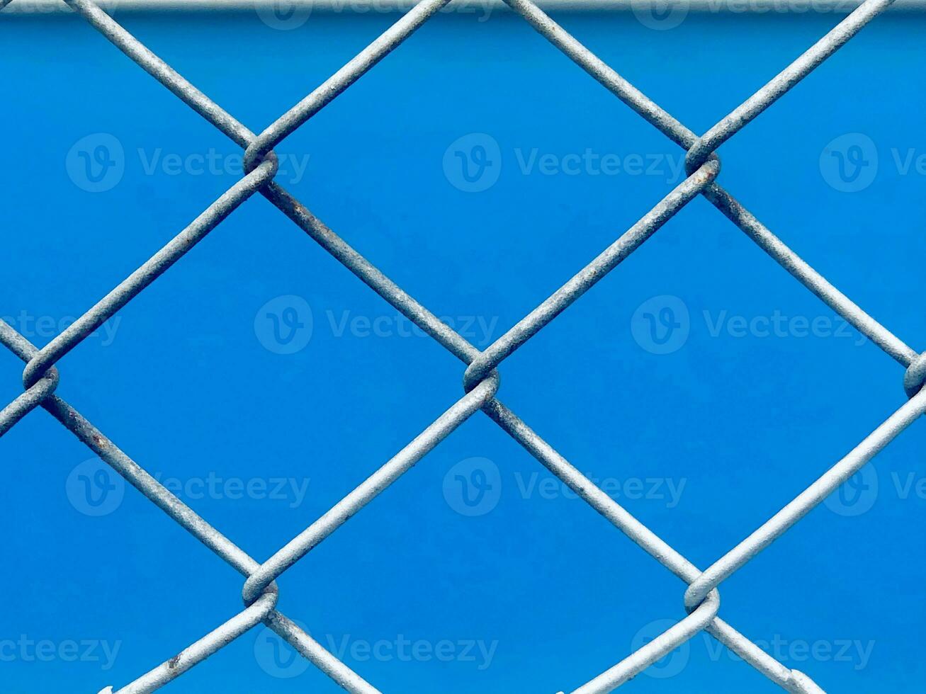 a blue background with a chain link fence photo
