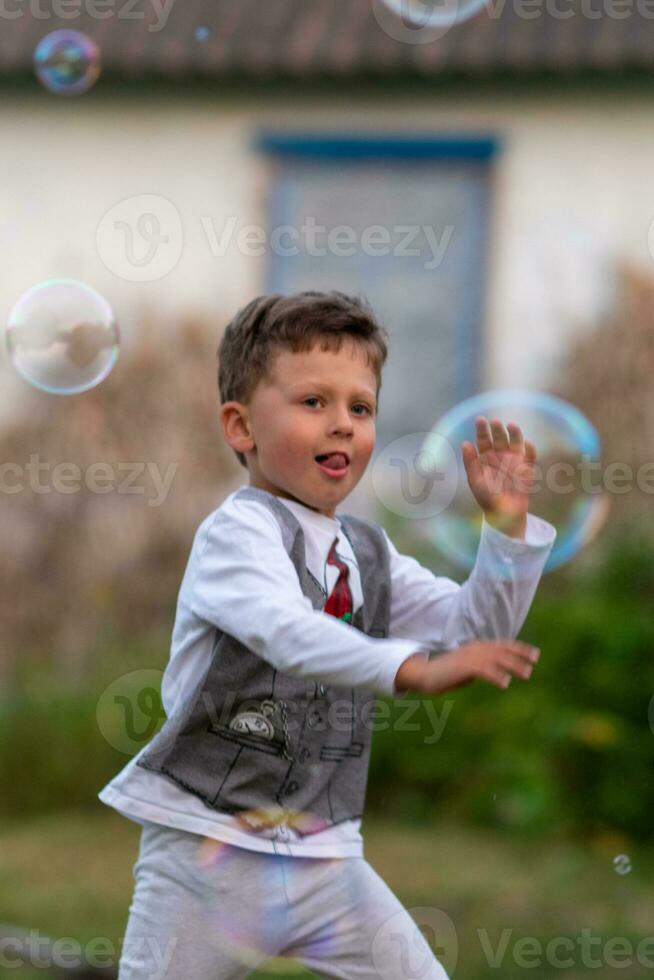 Beautiful baby boy with child soap bubbles posing photographer for cool photo