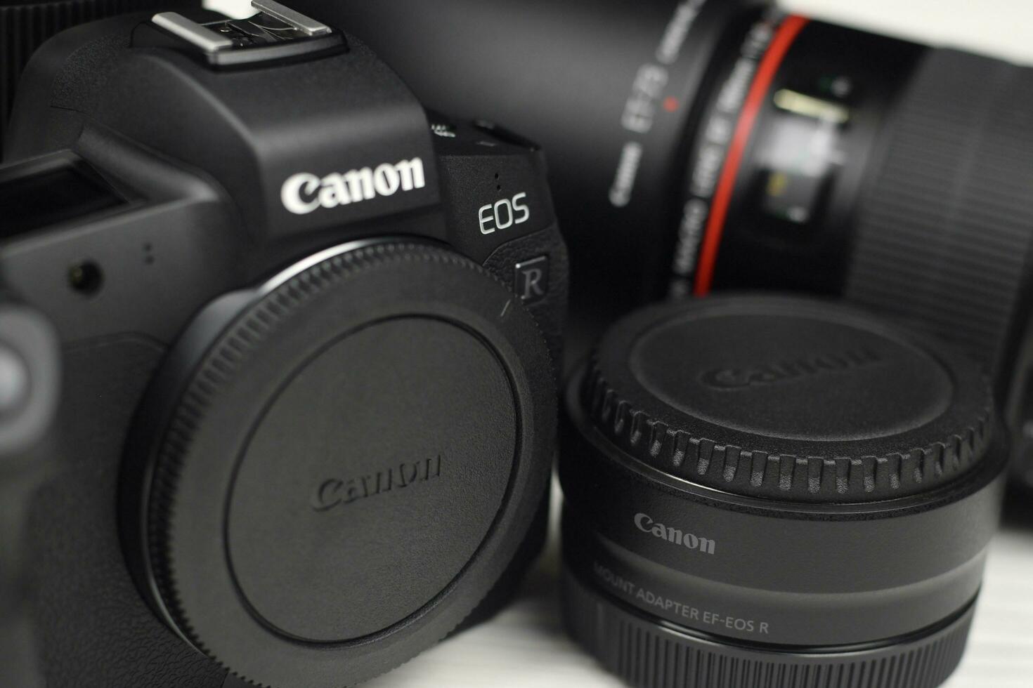 Canon EOS R photocamera and mount adapter EF - EOS R with Canon 105mm f2.8 and Sigma 24-105 f4 Art lenses on white wooden table photo