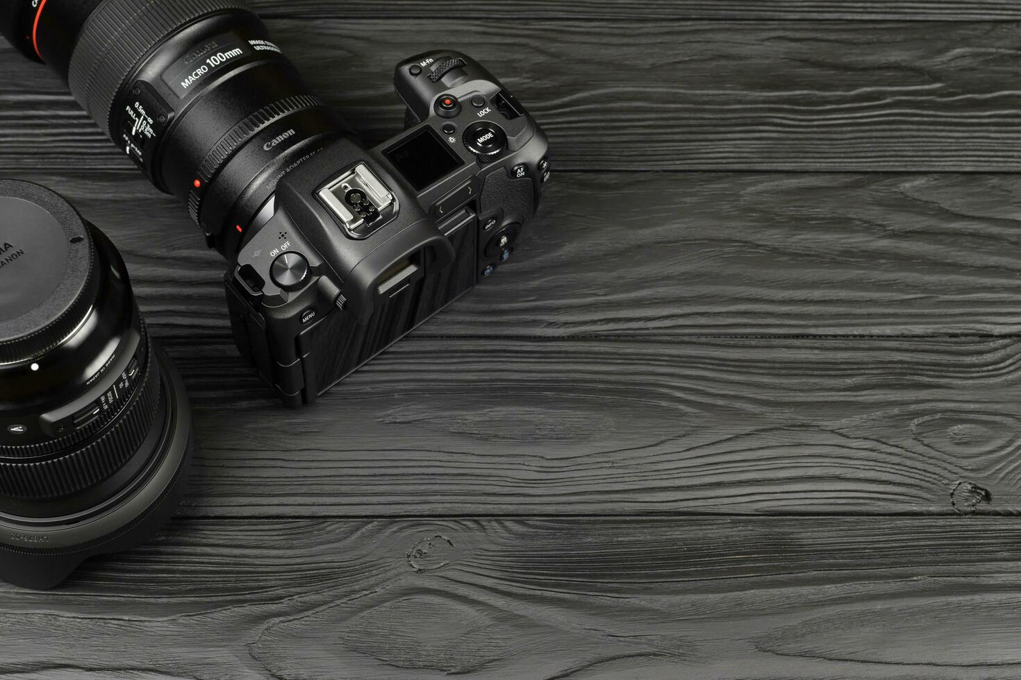 Canon EOS R photocamera and mount adapter EF - EOS R with Canon 105mm f2.8 and Sigma 24-105 f4 Art lenses on black wooden table photo