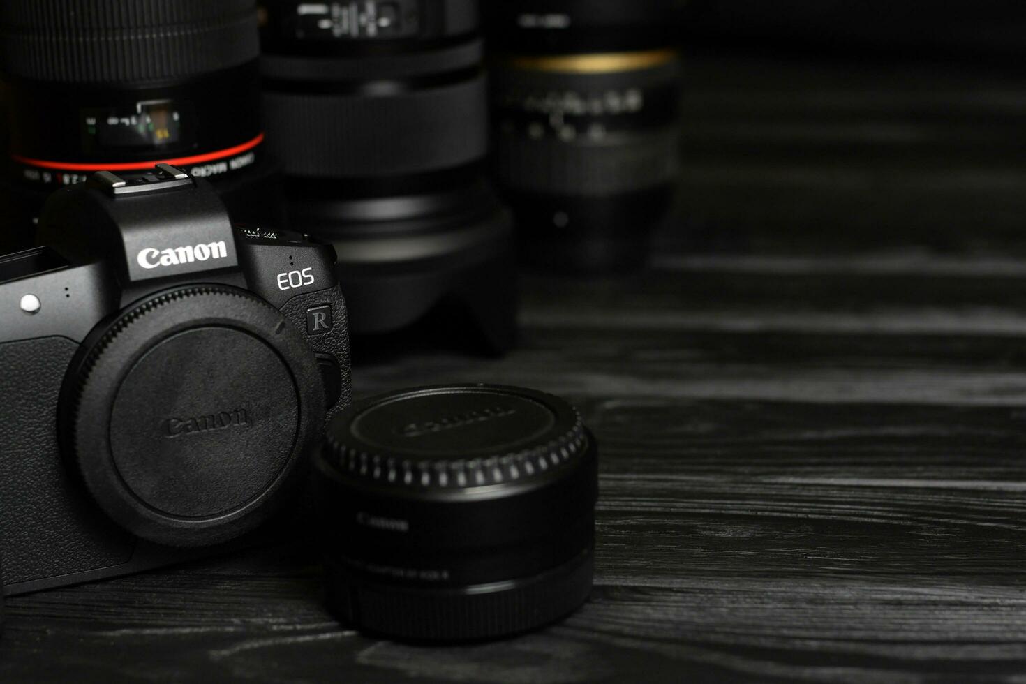 Canon EOS R photocamera with Canon lenses on black table. Canon EOS R is 30mp full-frame mirrorless interchangeable-lens camera launched by Canon in 2018 photo